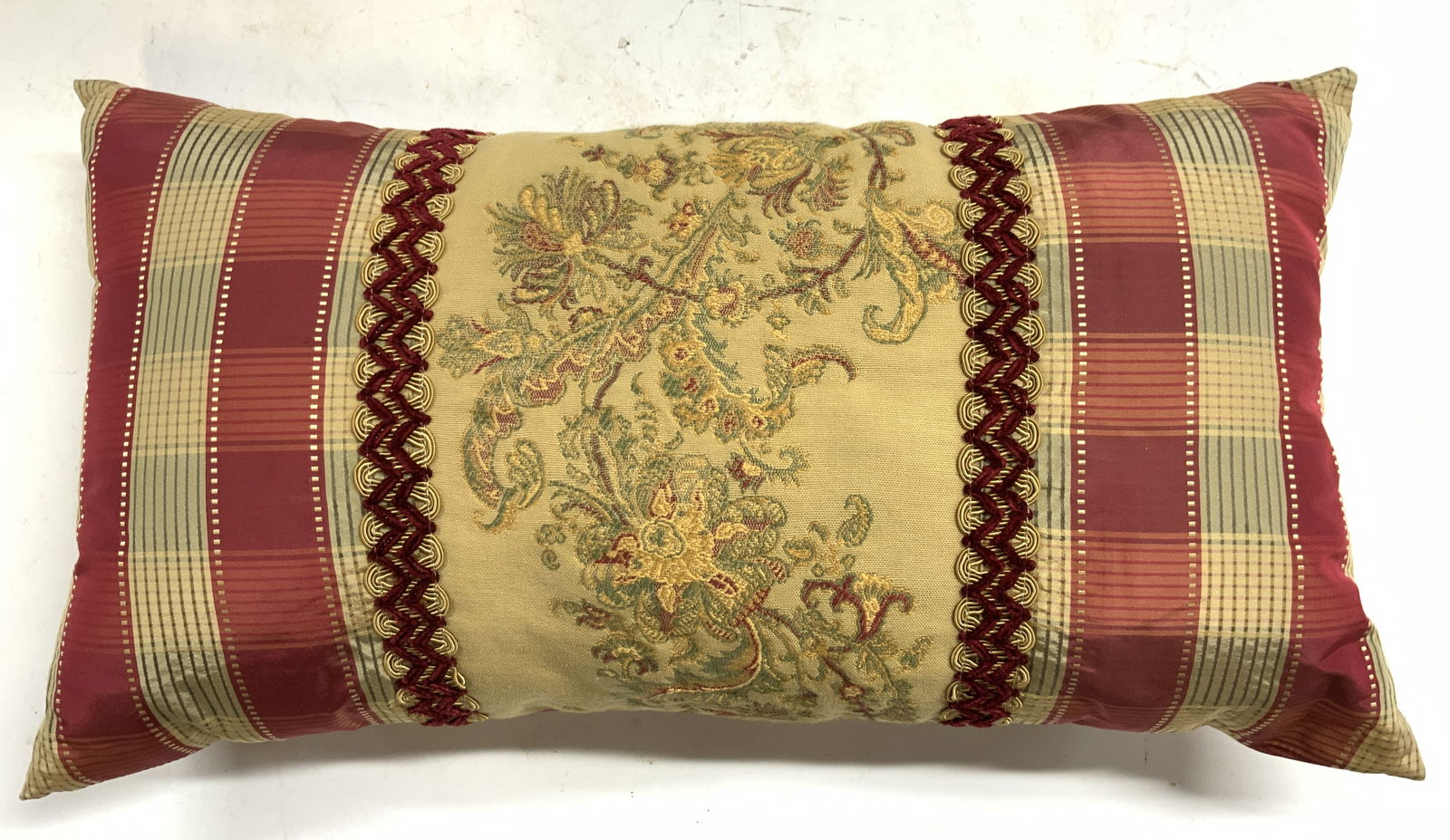 Floral & Striped Throw Pillow W Gimp Detail: Throw pillow has red, gold and olive toned striped detail. Center of pillow has floral motif needlepoint style detail with golf and wine red toned gimp detailing at edges. Pillow measures approximatel