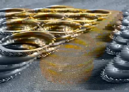 Set 11 Gilt Metal Ribbed Napkin Rings: Lot includes 11 napkin rings. Each are gold toned gilt metal with silver toned & copper toned detail near edges. Napkin rings are ribbed. Each have circular form. Napkin rings measure approximately 2