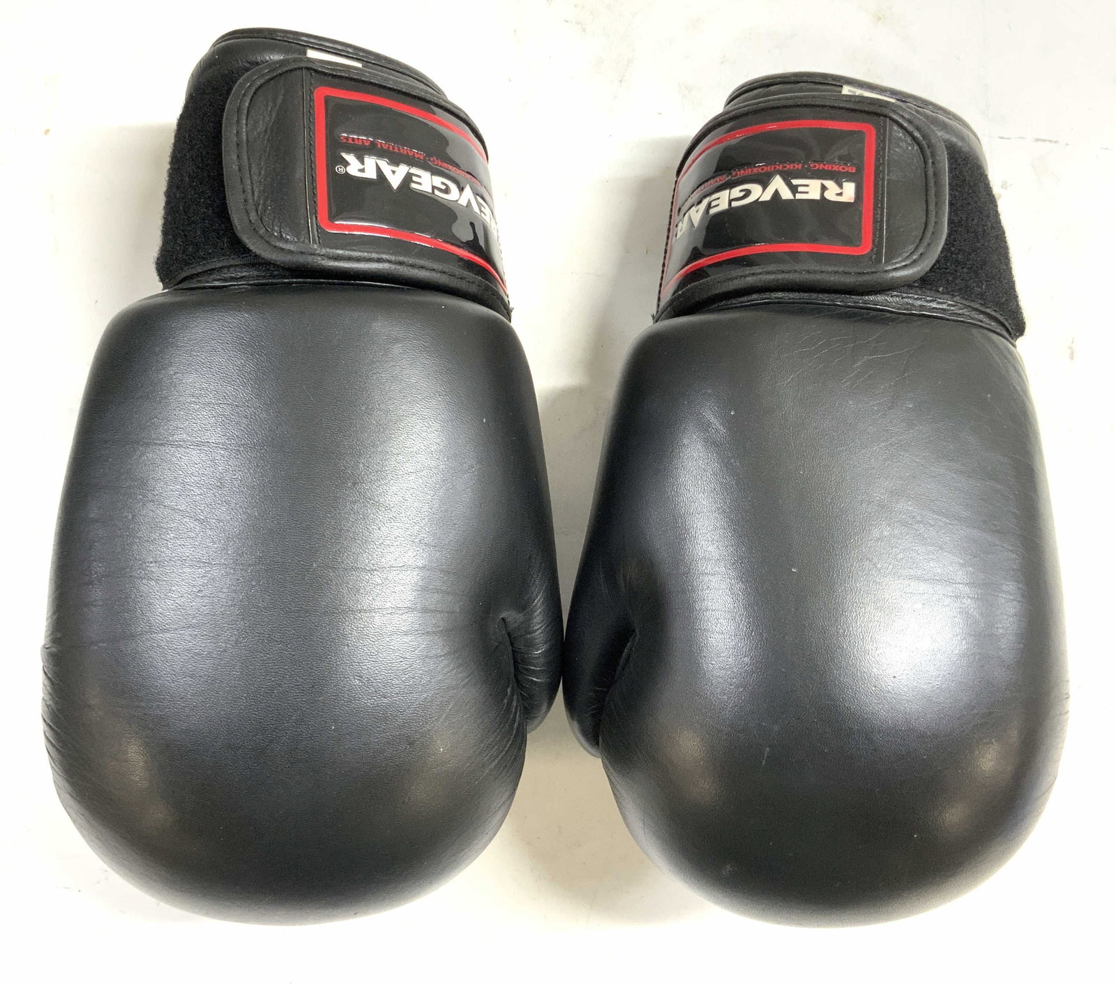 REVGEAR 14oz Black Leather Boxing Gloves: Strap is trademarked REVGEAR. Boxing gloves are black toned & leather (possibly leatherette). Each glove has Velcro strap. Tags read 14 Oz. Each glove measures approximately 11.5 inches long 6.25 inch