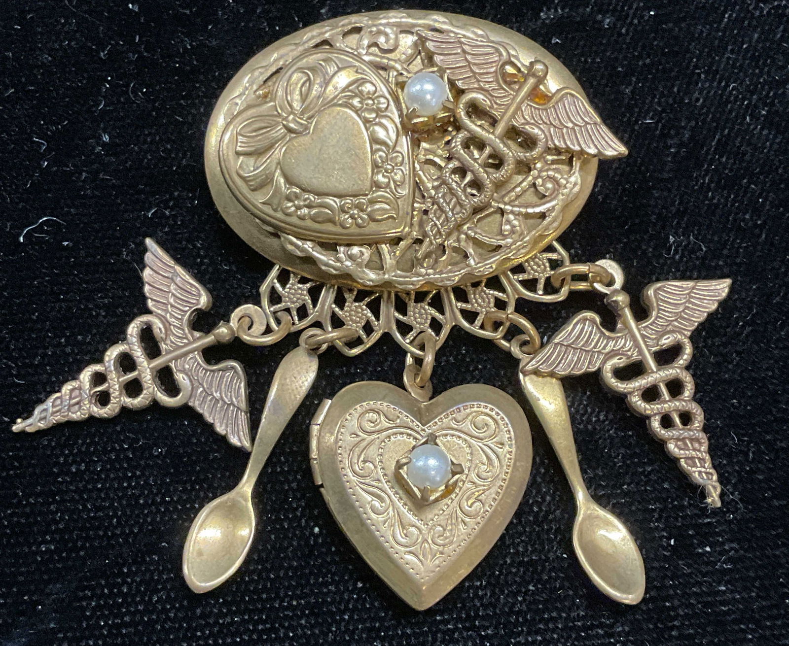 Vtg Gold Tn Heart Locket Pendant Brooch: Vintage handmade gold tone pendant brooch with heart locket, spoon, and medical motif pendants. Measures approx 2 x 1.5 inches. Some wear including scratching observed. Jewelry, estate jewelry, costum