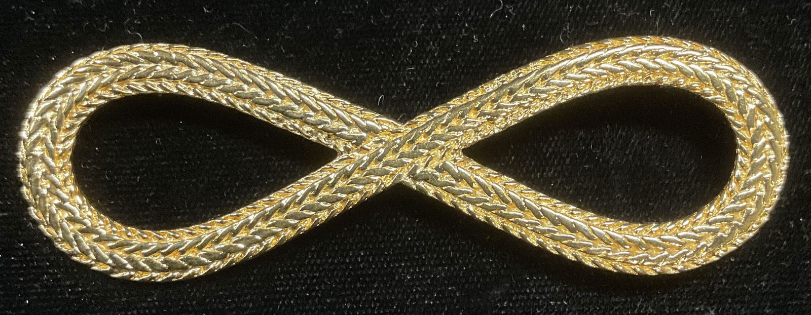 Monet Gold Tone Looped Cable Brooch 3.5 In: Vintage Monet gold tone looped cable motif brooch. Signed. Measures approx 1 x 3.5 inches. Some wear including scratching observed. Jewelry, estate jewelry, costume jewelry, cocktail jewelry, fashion