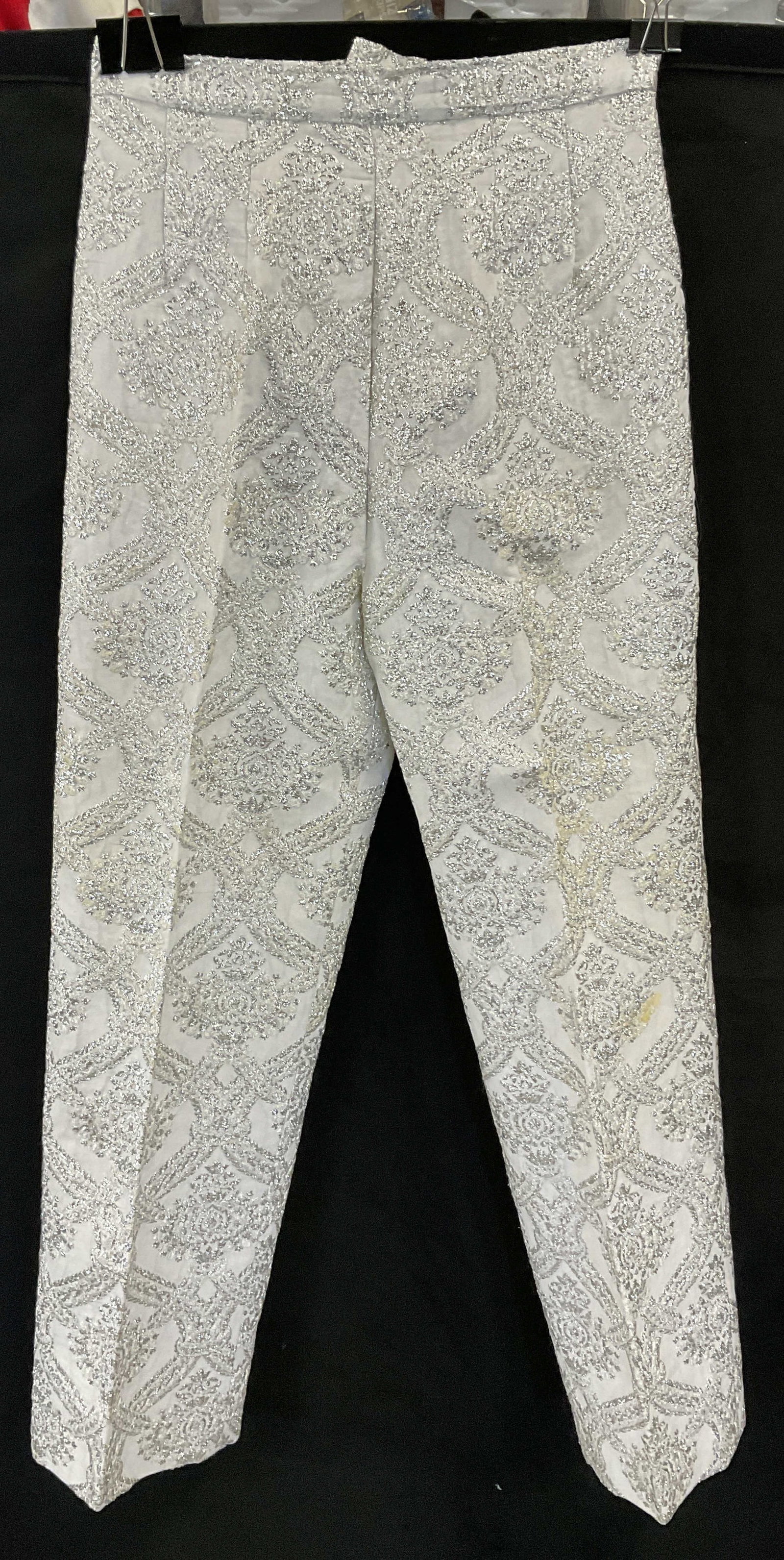 Vintage Metallic Thread Embroidery Pants: Vintage Metallic Thread Embroidery Pants. White hued pants with silver tone metallic thread embroidery. Zipper closure. No brand or fabric tag, possibly handmade Measured flat 13 inches across the wai