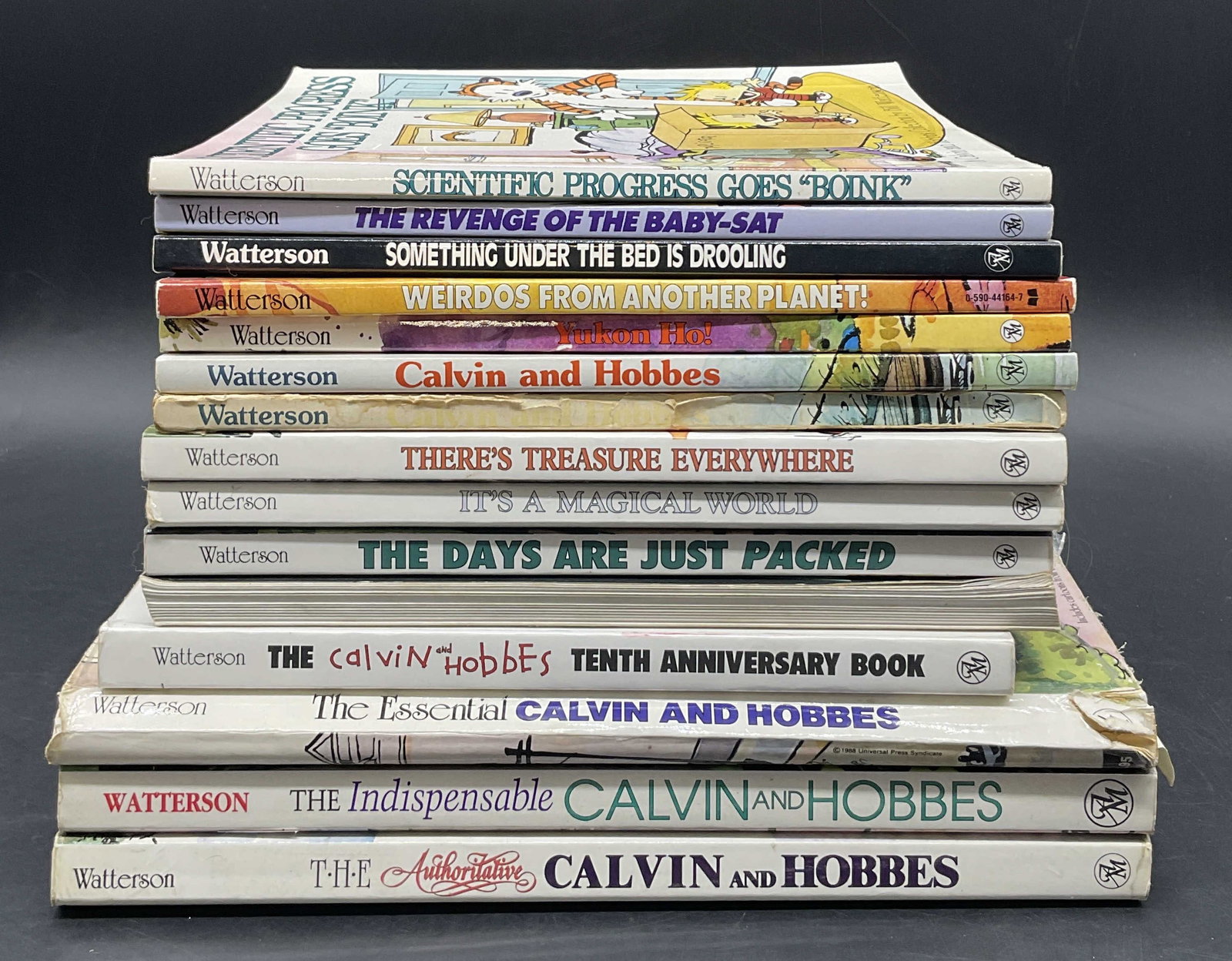 15 Calvin & Hobbes Watterson Illstr Books, 1991+: A group lot of Calvin & Hobbes paperback books. Includes SCIENTIFIC PROGRESS GOES BOINK, A Calvin and Hobbes Collection by Bill Watterson, C. 1991. This book measures approx. 8.75W x 9L in. The books 