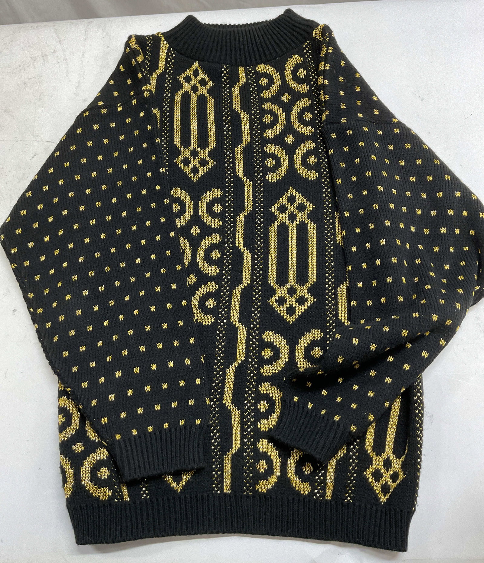 Vtg Arielle Acrylic Black Gold Crewneck Sweater US: Vintage Arielle acrylic black gold crewneck sweater. Black weather with gold thread art deco pattern designs. Ribbed rounded neck. 18 inches across chest. Made in USA. 80% acrylic, 10% lurex, 10% rayo