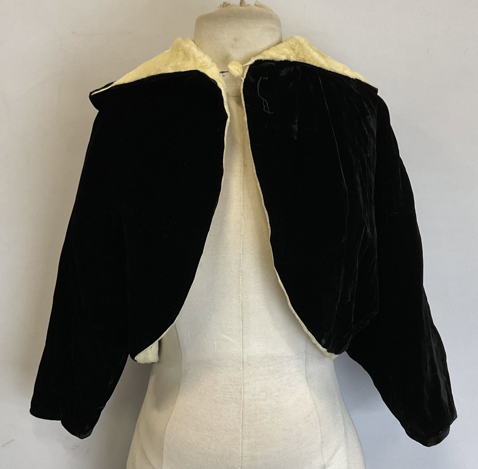 Vtg Black Cream Velvet Cropped Hooded Top: Vintage black cream velvet cropped hooded top. Cream colored faux fur lining with black velvet outside. One button with elastic band closure. No material tag attached, material appears to be velvet an