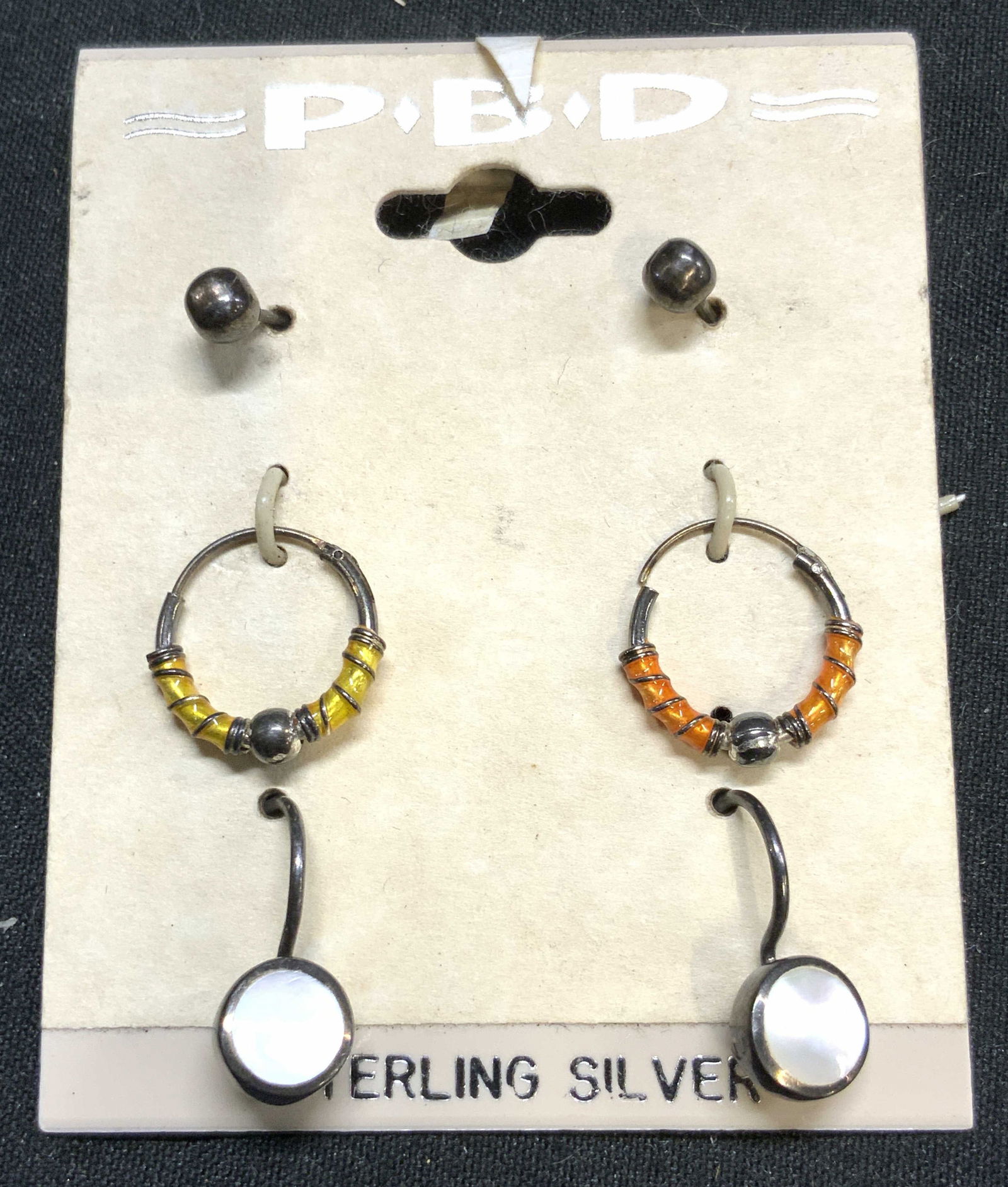 PBD Lot 6 Sterling Silver Asst Earrings W Pkg: Packaging reads STERLING SILVER. Lot includes 3 pairs of Earrings (6 total). Earring packing is trademarked PBD. Includes studs, beaded hoops & dangling earrings with white toned enamel areas. Hoop pa