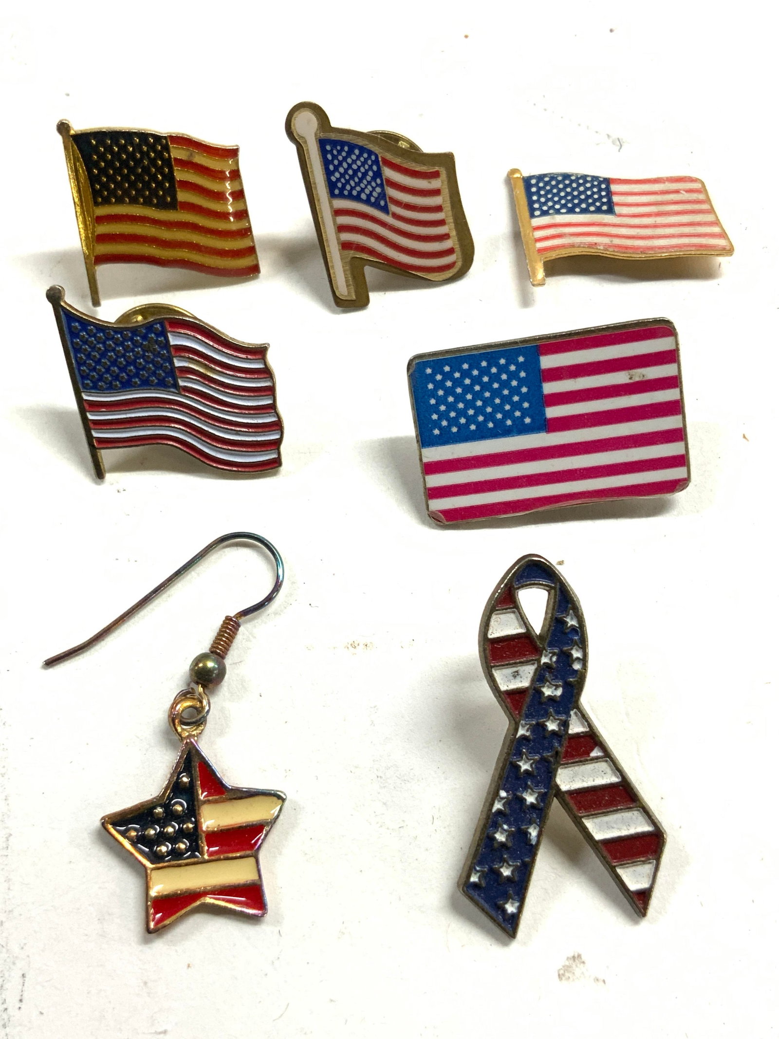 Lot 7 Asst Star Spangled Banner Pins & More: Lot includes 5 star spangled banner/ American flag pins & 1 American flag star form enameled earring. Each piece appears to be vintage. Largest pin measures approximately 1.25 inches tall .75 inches w