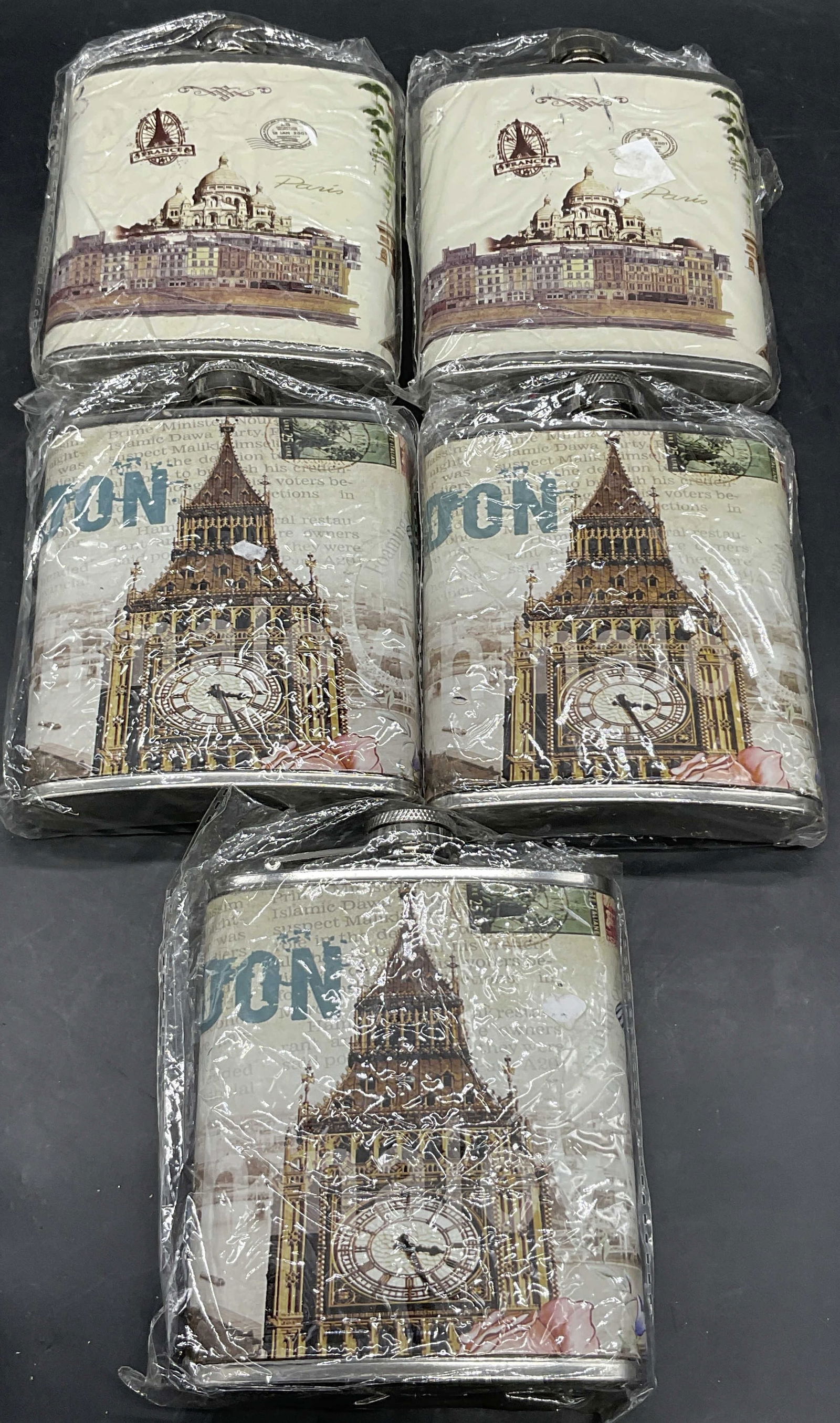 5 NIP Stainless Steel London & Paris Motif Flasks: Lot of five stainless steel faux leather wrapped Paris and London city motif flasks. 7 ounce size. Measure approx 5H x 4W in. New in packages. Some surface wear to packaging. Flasks not examined out o