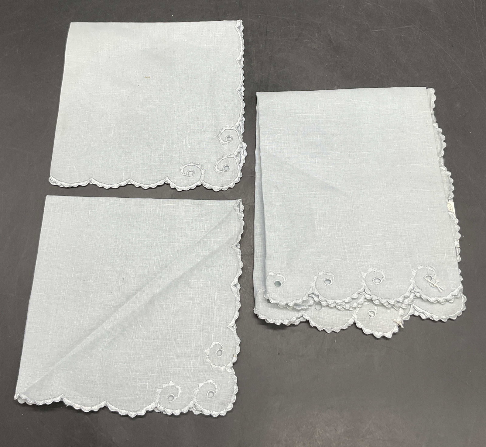 3 LEACOCK Hand Embroidery Linen Napkins & Placemat: Set of 3 LEACOCK Hand Embroidery Linen Napkins & Placemat. Light blue hued linen napkins with swirl accents. Placemat has a tag attached which reads LEACOCK Hand Embroidery 100% Linen, Portugal. Disco