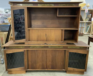 Vintage Wood & Veneer Entertainment Center: Entertainment center is vintage and wooden/ wood veneer. Piece has 2 rolling cabinet doors, 1 upper cabinet & 2 lower cabinets. Lower cabinets have glass shelves. Measures approximately 86 inches long