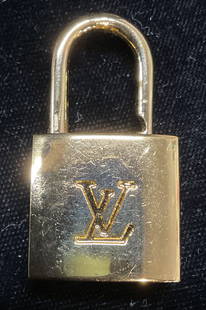 Gold Tone Louis Vuitton Padlock, France: Gold tone Louis Vuitton padlock. Signed on metal. Made in France. Measures approx 1.5 x .75 inches. Lock only. Some wear including scratching observed. Jewelry, estate jewelry, costume jewelry, cockta