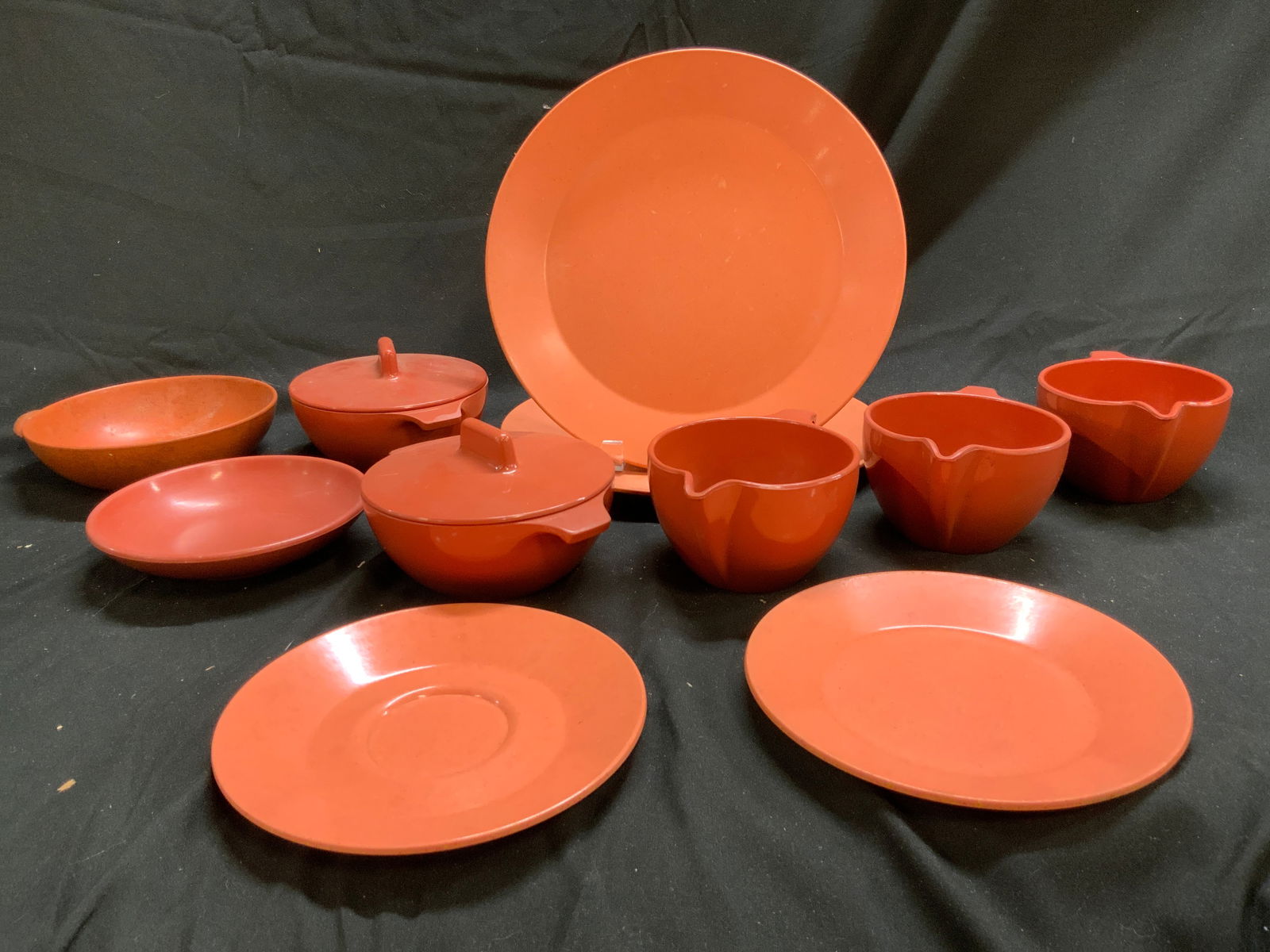Lot 11 Asst Melamine Dishware Orange: Trademarks include CADENCE, LIFETIME WARE, BRANCHELL, & MONTEREY MELMAC. Lot includes 2 dinner plates, 1 saucer, 3 creamer dishes, 2 bowls with handles and lids, 1 dessert bowl, 1 bow with lid and 1.
