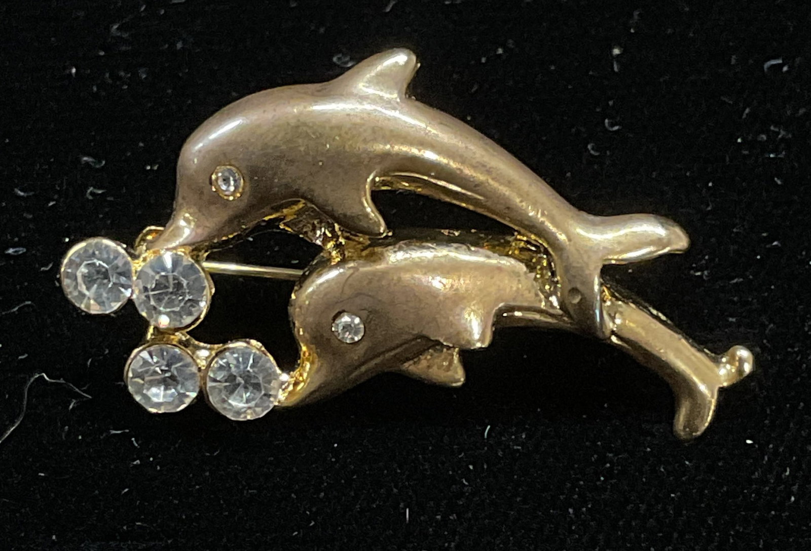 Vintage Gold Tone Crystal Dolphin Brooch: Vintage gold dolphin motif brooch with colorless crystal. Measures approx .75 x 1.25 inches. Some wear including scratching observed. Jewelry, estate jewelry, costume jewelry, cocktail jewelry, fashio