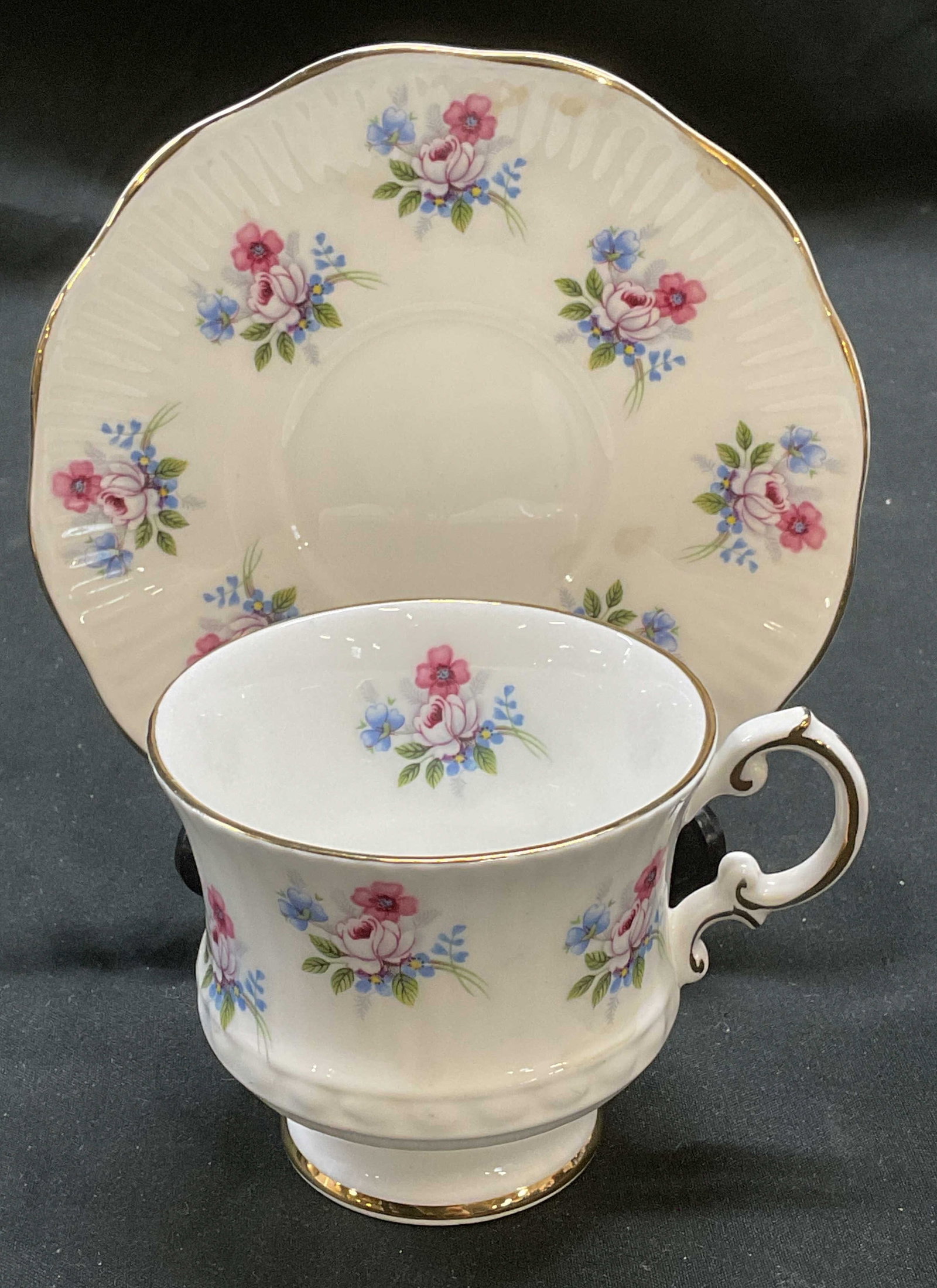 Elizabethan Fine China Floral Teacup & Saucer: Elizabethan fine bone china teacup and saucer with floral pattern. Signed. Made in England. Saucer approx 5 inches, teacup approx 3 x 2.75 inches. Some scratching observed to each. Elizabethan China, 