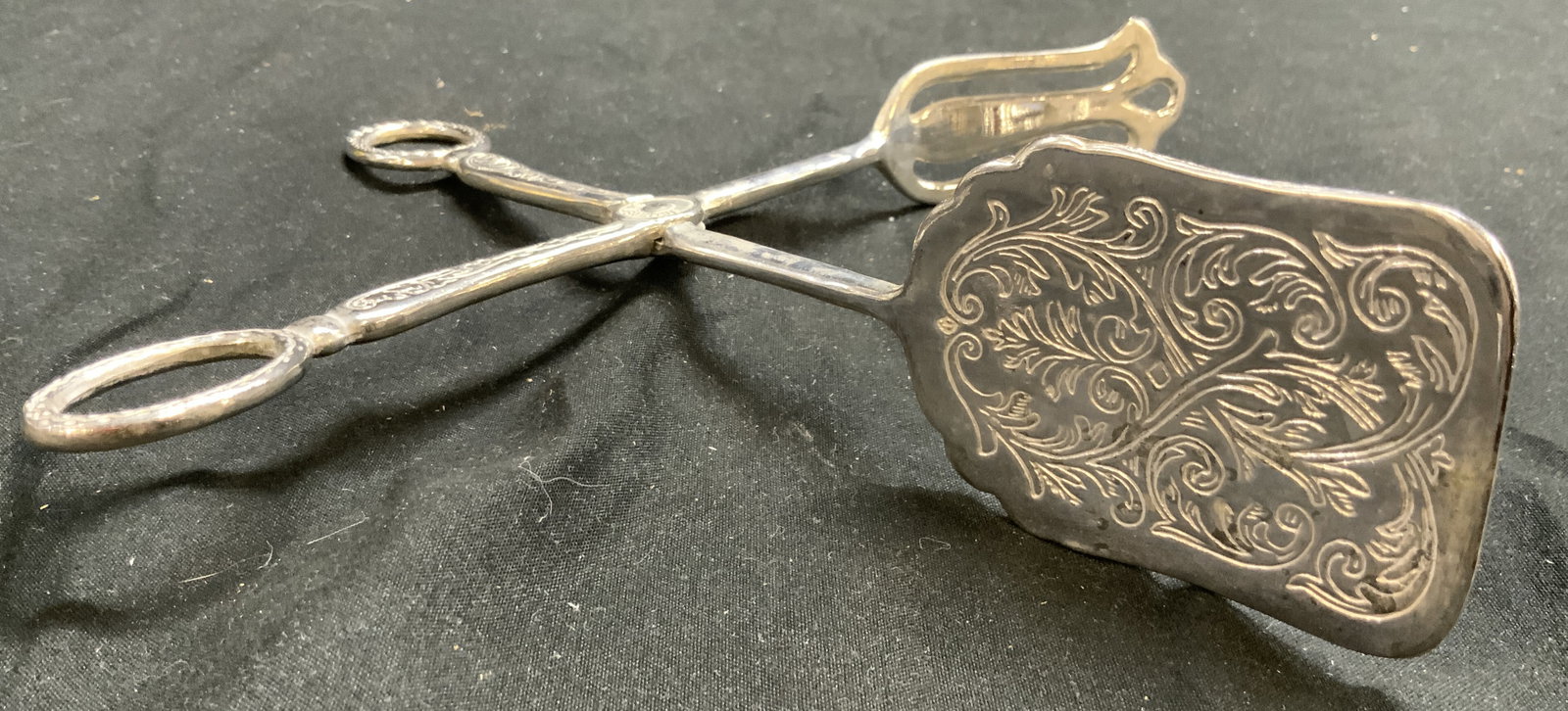 Silverplate Vintage Ornate Cake Tongs: Cake tongs read SILVERPLATE In center. Tongs are vintage. Piece has ornate scroll relief detail. Pierced detail to one side. Measures approximately 6 x 6 inches when fully open. Tongs, silver plate to
