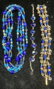 Lot 3 Blue Art Glass Necklaces & Bracelets: Lot of 3 jewelry pieces. Blue art glass necklace and 2 bracelets. Handmade paperclip bracelet, round bead bracelet, and beaded necklaces. Necklace drop length approx 30.5 inches. Longer bracelet appro