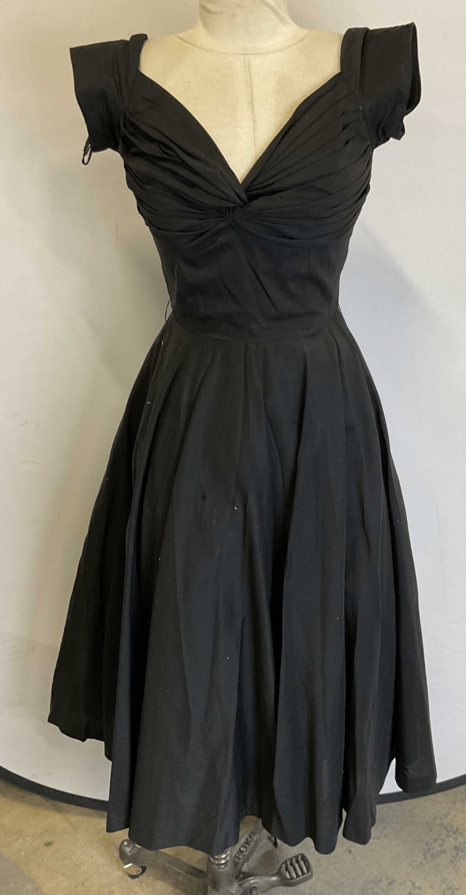 Vtg Black Multilayer Pleat Knot Swing Skirt Dress: Vintage black multilayer pleat knot swing shirt dress. Pleat knot front with fun swing skirt design. 17.5 inches across chest. No material tag attached, appears to be satin or synthetic mix. Some surf