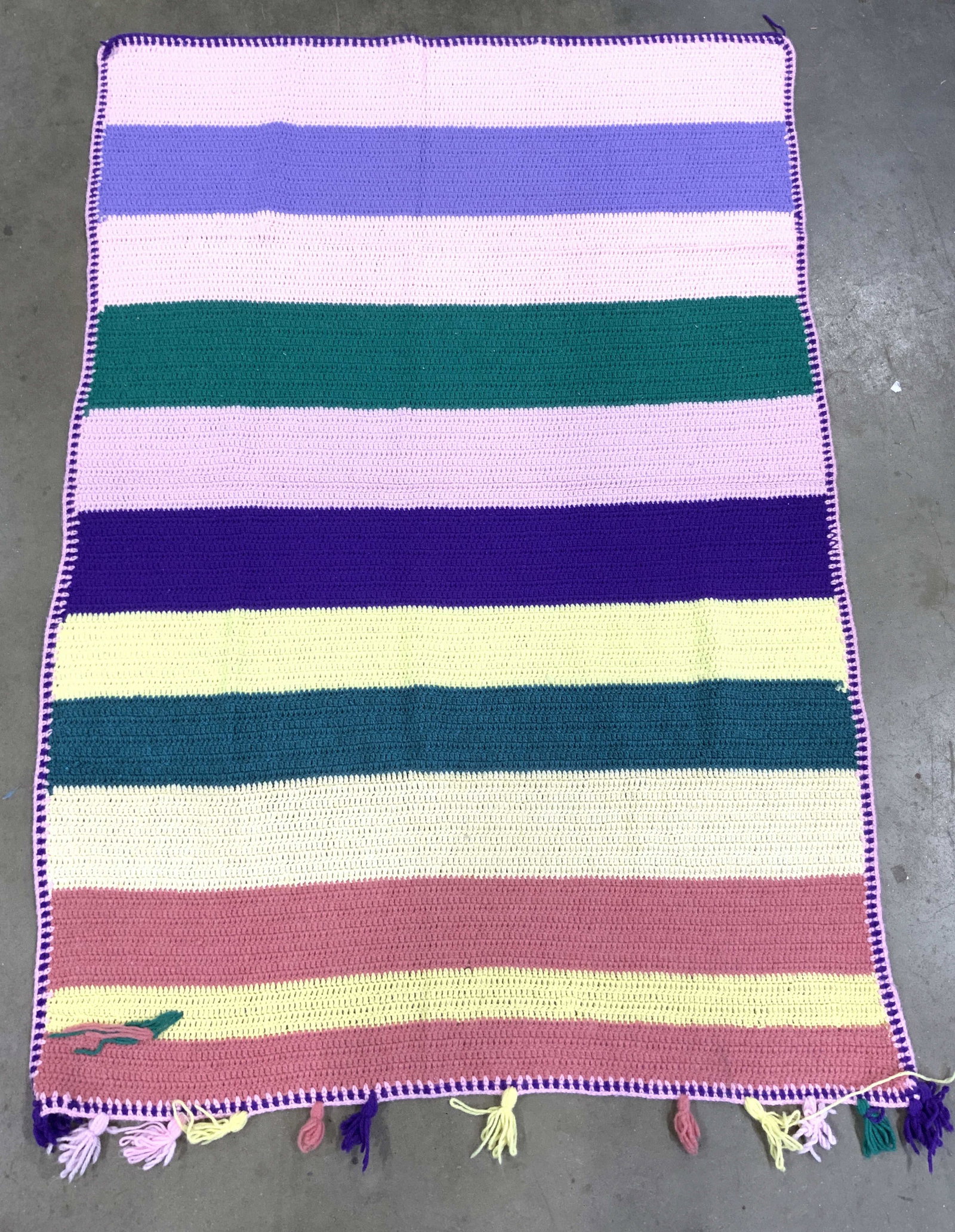 Striped Woven Yarn Blanket W Fringes: Blanket is crafted from woven yarn. Piece has teal, cream yellow , pink, salmon and purple toned striped detail. Edges of blanket has stripes. Piece measures approximately 61 inches long 40 inches wid