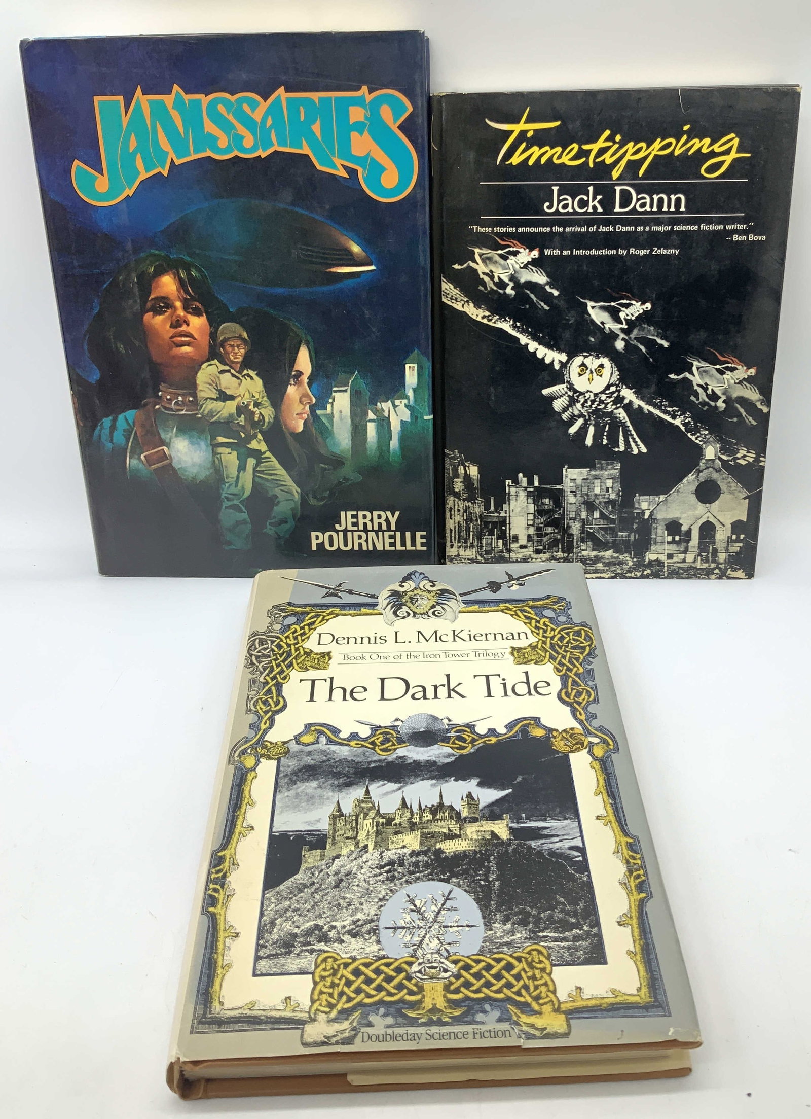 3 Illustrated First Ed. 1970-1980s Books DANN+: Lot includes, The Dark Tide by Dennis McKiernan, Timetipping by Jack Dann & Janissaries by Jerry Pournelle. Books feature illustrations on front cover. COPYRIGHT 1979 by JERRY POURNELLE. FIRST ACE PRI