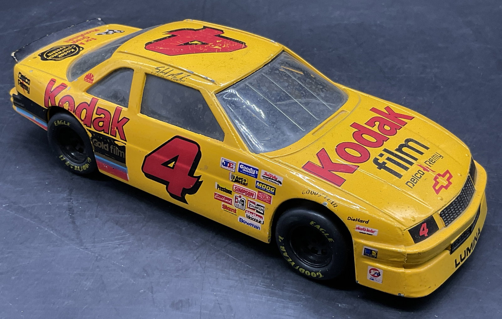 1992 RACING CHAMPIONS Die Cast #4 Kodak NASCAR: Die Cast #4 Kodak Film Chevrolet Lumina NASCAR Car Model. This was modeled after the car driven by Ernie Irvan. Underside reads 1992 RACING CHAMPIONS. Measures approx. 2.25H x 8W in. Wheels roll. Surf