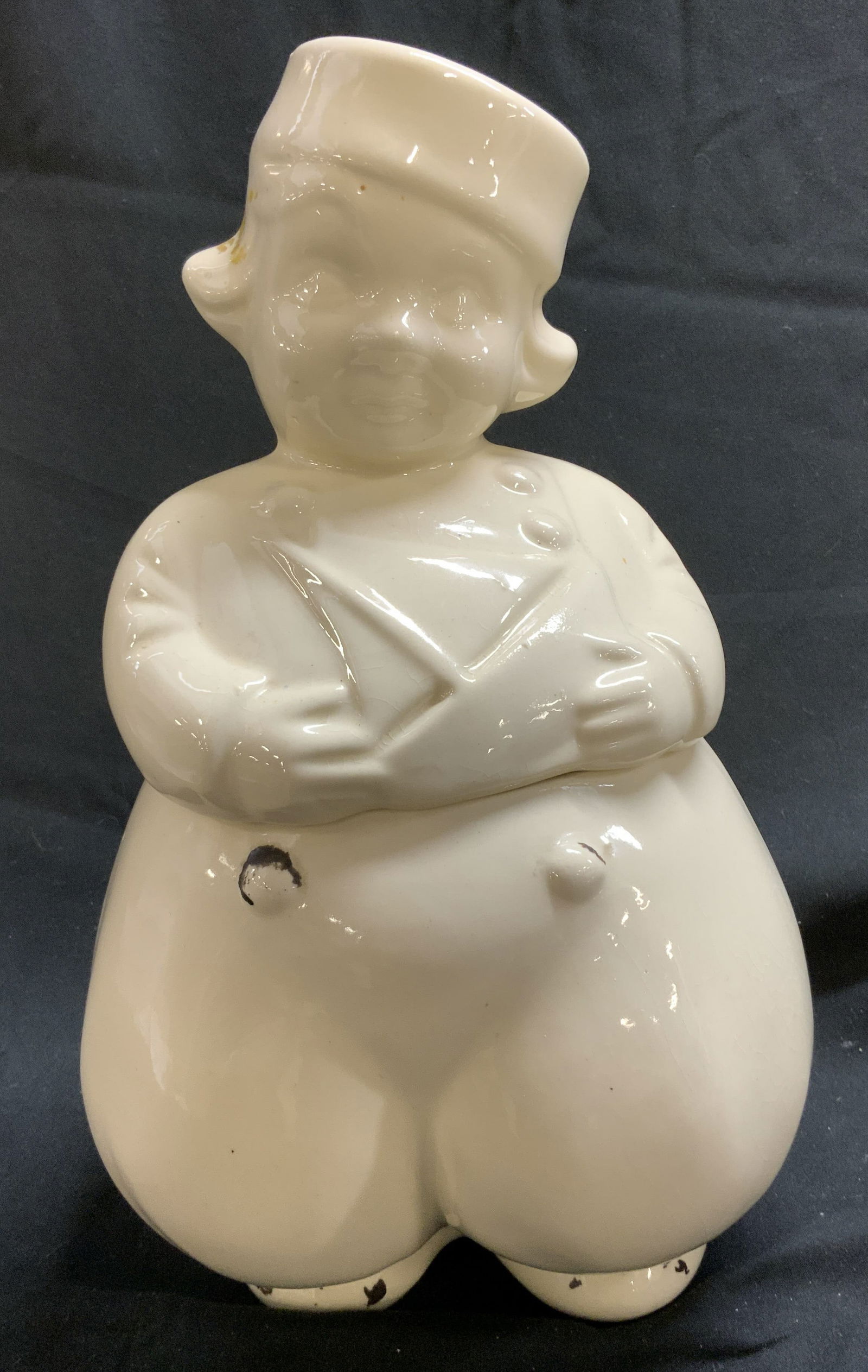 Vintage American Bisque Sailor Boy Cookie Jar: Cookie jar features a Dutch boy in a sailor outfit. Vintage jar has a white glossy finish. Surface wear consistent to age, use & exposure. Measurements: length 5.2in x width 5in x height 13in. Vintage