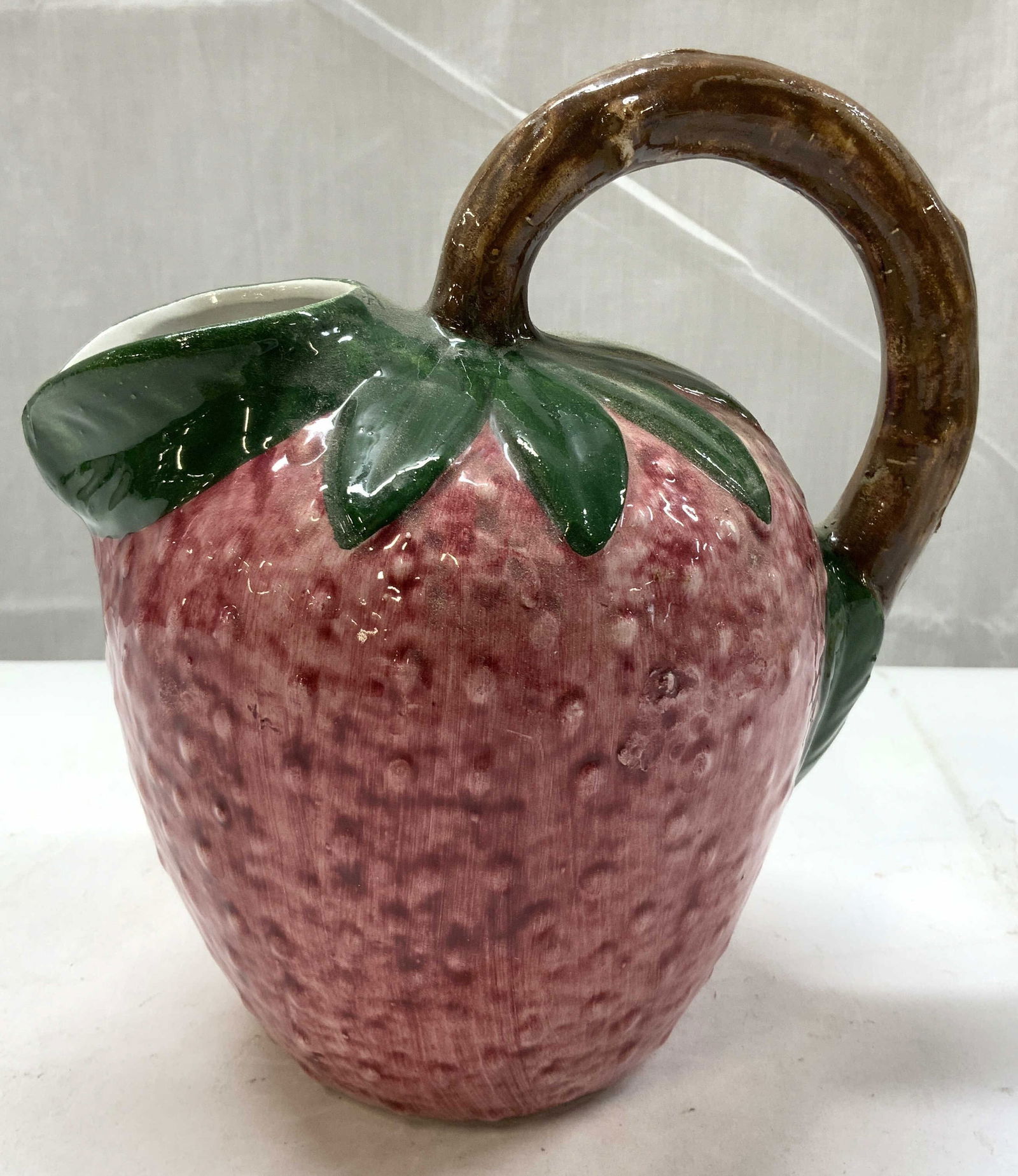 Vintage Ceramic Glossy Strawberry Pitcher ITALY: Vintage Ceramic Glossy Strawberry Pitcher ITALYHand-painted textured strawberry pitcher with green leaves & a brown handle. Pitcher has a glossy finish. Underside has markings, Reads MADE IN ITALY, re