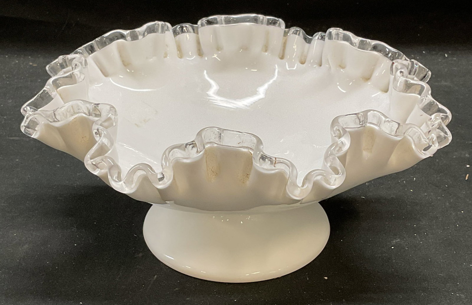 Vintage Milk Glass Footed Handkerchief Bowl: Vintage milk glass bowl. Footed with handkerchief and clear glass rim. Thick walled glass, piece has weight. Style of Fenton, no visible marks. Measures approx 8 x 4 inches. Some wear consistent with 