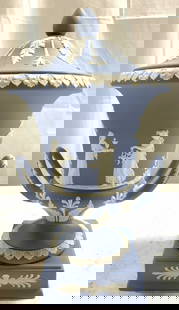 WEDGWOOD Blue Jasperware Ped Campagna Urn W Lid: Underside is inscribed WEDGWOOD MADE IN ENGLAND. Urn is pedestaled. Pedestal Campagna vase. Light blue and white toned Jasperware urn with handles and lid. Piece has square form base. Urn has female f