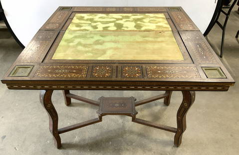 Vintage Inlaid Moorish Folding Game Table: Game table is vintage. Moorish game table with folding top, & intricate inlay detail. Center has green toned felt insert. Corners have gilt metal ash trays. Measures approximately 31 inches tall 35 in