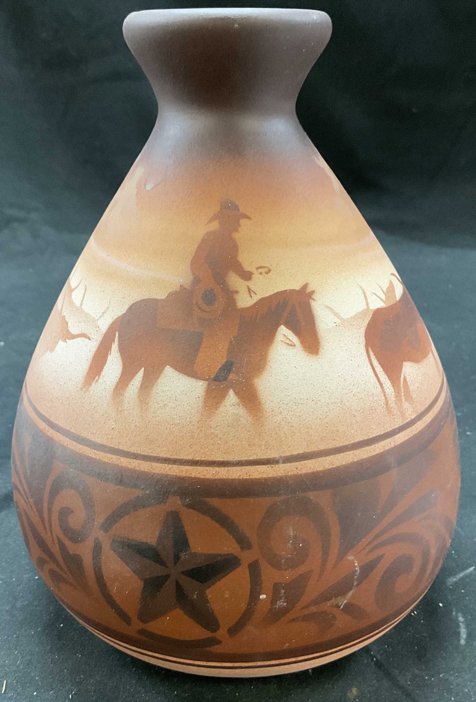 DINE signed Vtg Native American Southwest Vase: DINE signed Vtg Native American Southwest Vase. Native American southwest pottery vase. Piece is raw sienna with brown toned depictions of a figure riding horseback following oxs. 8.5 x 6 inches. Some