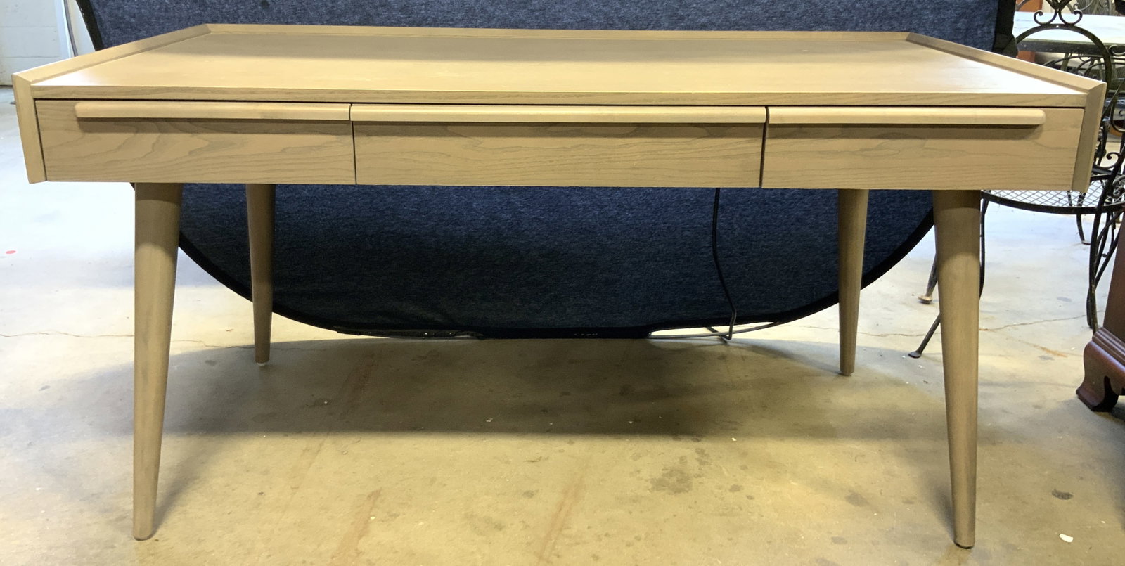 CRATE & BARREL TATE MCM Splayed Leg Dsk: Pamphlet reads CRATE & BARREL TATE. Interior of top left drawer also reads CRATE & BARREL. Desk is tan toned wood veneer. Piece has 3 drawers, each with dovetailing. Desk Measures approximately 60 inc