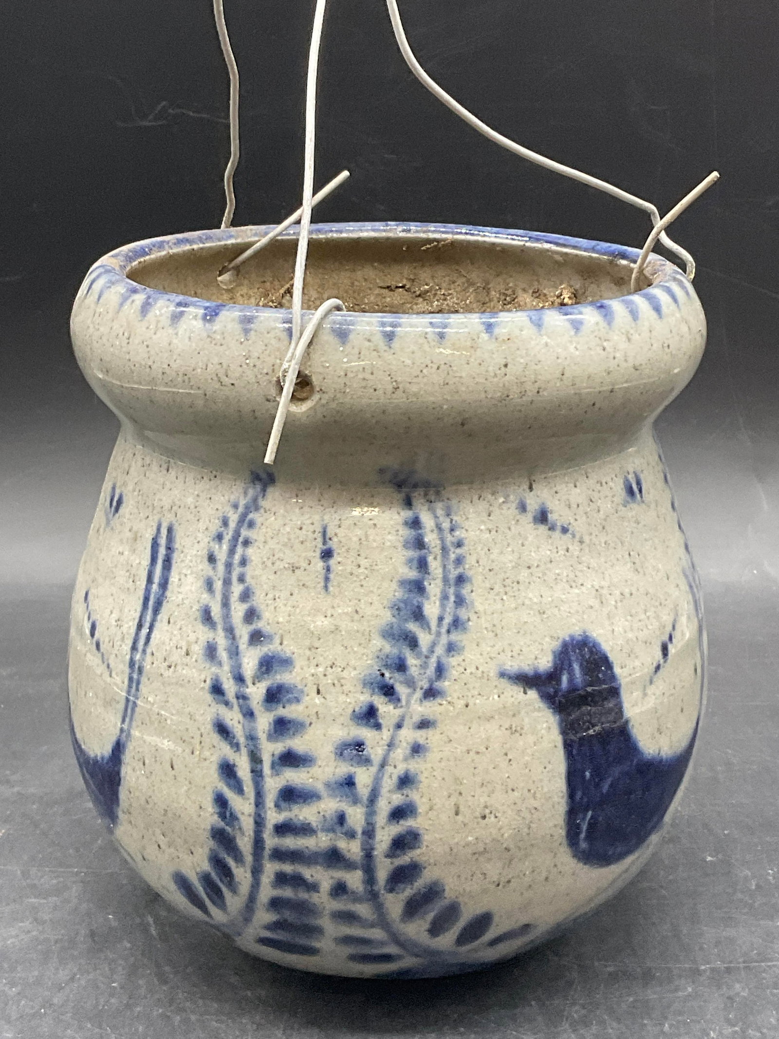 Vintage Bird Motif Pottery Hanging Planter: Vintage Bird Motif Pottery Hanging Planter. Metal wire hanger looped through drilled holes. Gray and blue hues throughout. Together pieces measure approx. 18.5H x 5W in. Discoloration, residue, plant 