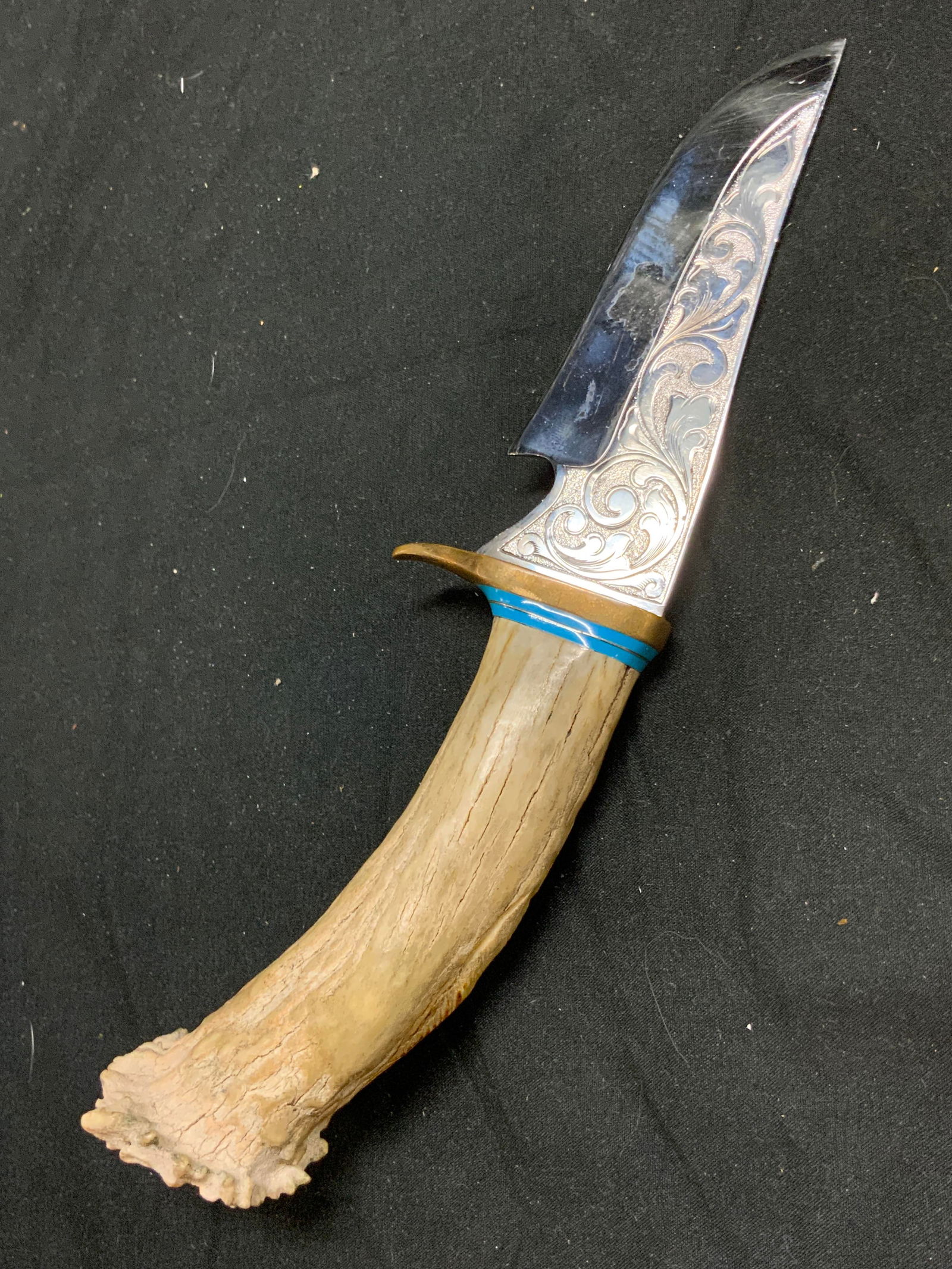 Bone Handle Fighter Knife Hunting Knife: Hunting knife has cream toned bone handle. Piece has silver toned metal blade with scroll and leaf detail. Edge of handle is gilt metal and light blue toned enamel. Knife appears to be vintage. Measur