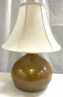 Vintage Ceramic Table Lamp W Shade: Table lamp is vintage. Piece is ceramic, beige with cream toned shade. Lamp possibly had crafted. Underside is lined with black toned felt. Piece has black toned twist switch. Lamp measures approximat