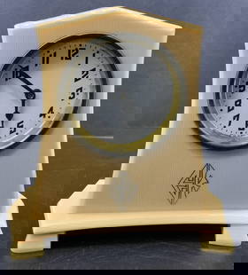 Vntg EK Art Deco Tuskeloid Mantel Brass Clock: Vntg EK Art Deco Tuskeloid Mantel Brass Clock Cream-colored mantel clock with an art deco design. Clock features a domed top & black numerals on a white dial, framed in a possible brass-tone trim. Sig