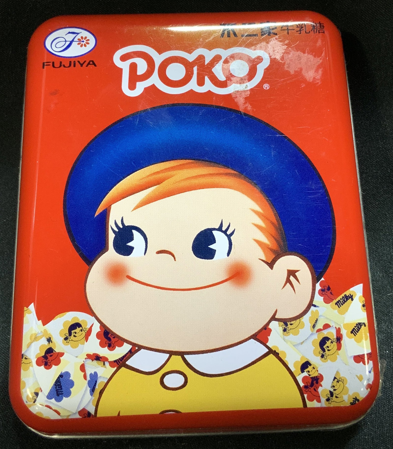 Fujiya Poko Milky Candy Souvenir Tin Box JAPAN 2007: Appears to be circa 2007. Fujiya Poko Milky Candy Souvenir Tin Box JAPAN Tin features an illustration of a baby smiling & wearing a blue hat. Tin has a red background. Marked with Asian characters thr