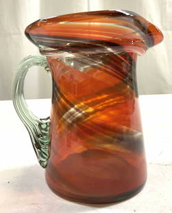 Vintage Hand Blown Murano Glass Pitcher: Pitcher appears to be MURANO glass. No apparent markings. Pitcher possibly hand blown due to slight pontil on underside. Vessel has orange & maroon toned swirl detail. Applied glass handle, Pitcher ha