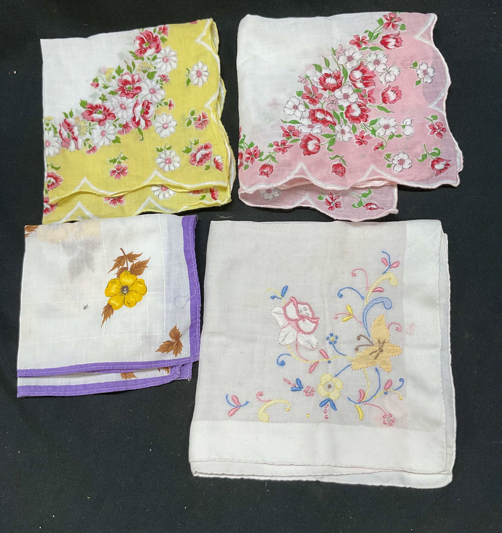 Lot 4 Vtg Cotton Embroidered Floral Handkerchiefs: Lot 4 vintage cotton embroidered floral handkerchiefs. Fringed floral pattern designs in pink, yellow, and purple. Embroidered floral pattern designs. Largest handkerchief measures 13 inches. Material