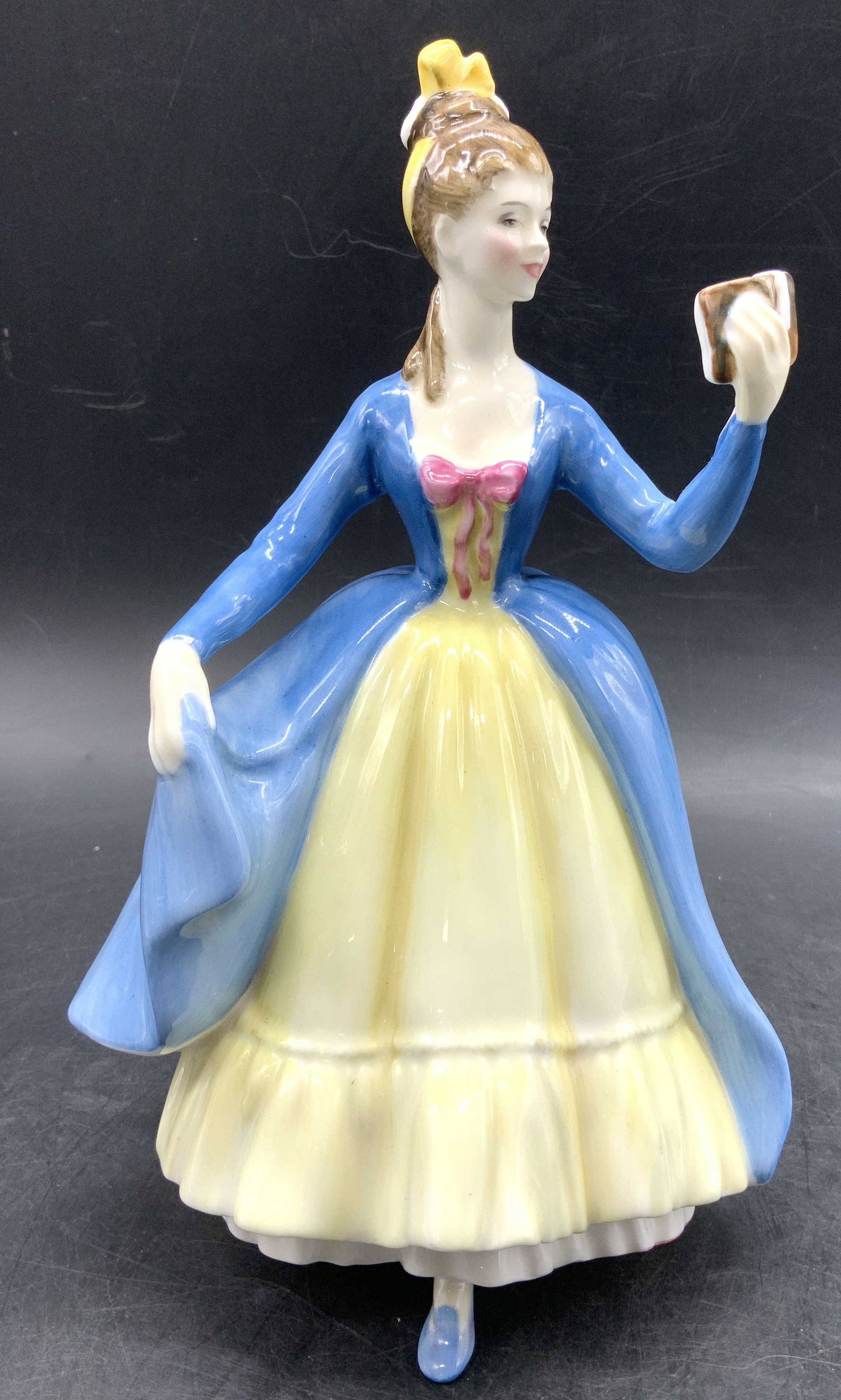 ROYAL DOULTON Leading Lady Porc Figurine ENGLAND: ROYAL DOULTON Leading Lady Porc Figurine ENGLAND Porcelain figurine depicting leading lady wearing a blue gown with a yellow skirt & is holding a book in her raised hand. Signed & marked on underside.