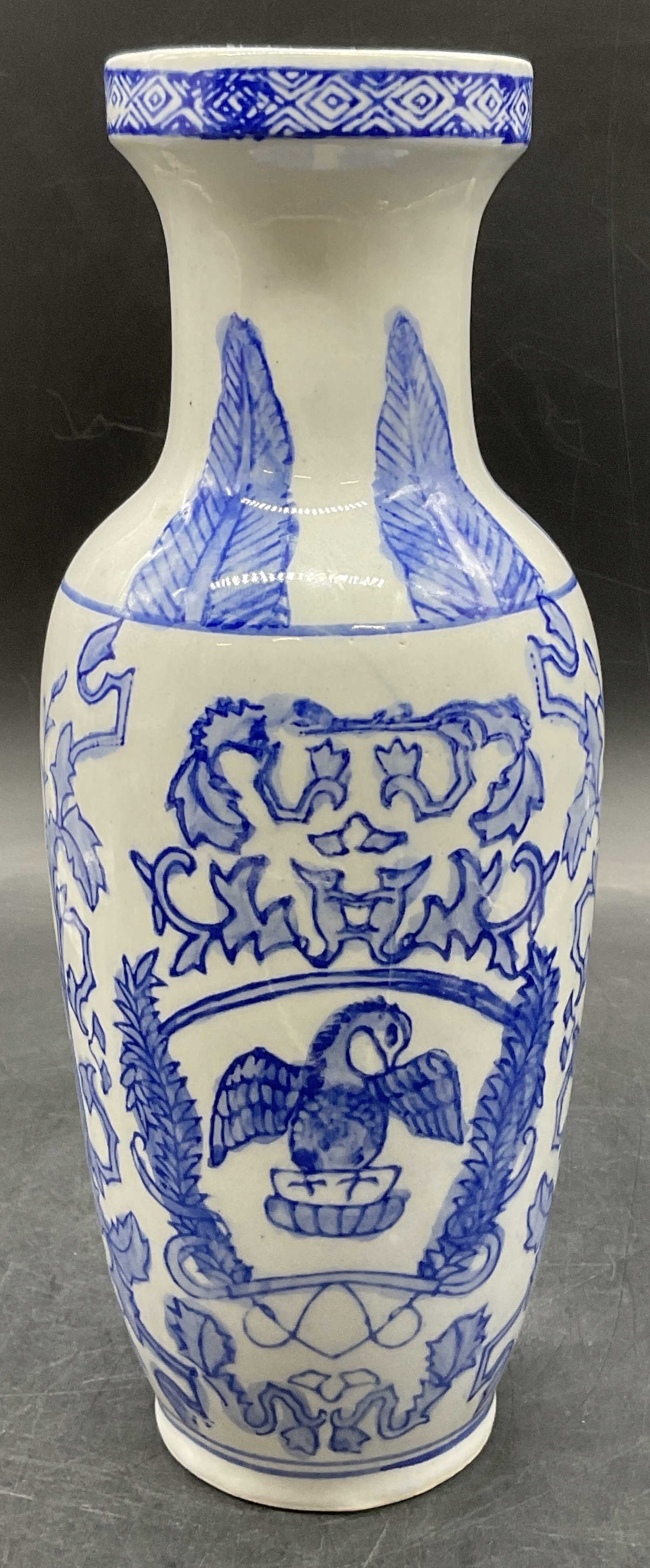 Vintage Blue & White Asian Porcelain Vase: Vintage Blue & White Asian Porcelain Vase. Hand painted elements to the piece. Features foliage, geometric patterns, and bird motifs. Measures approx. 10H x 4W in. Measured at widest point. Pitting, r