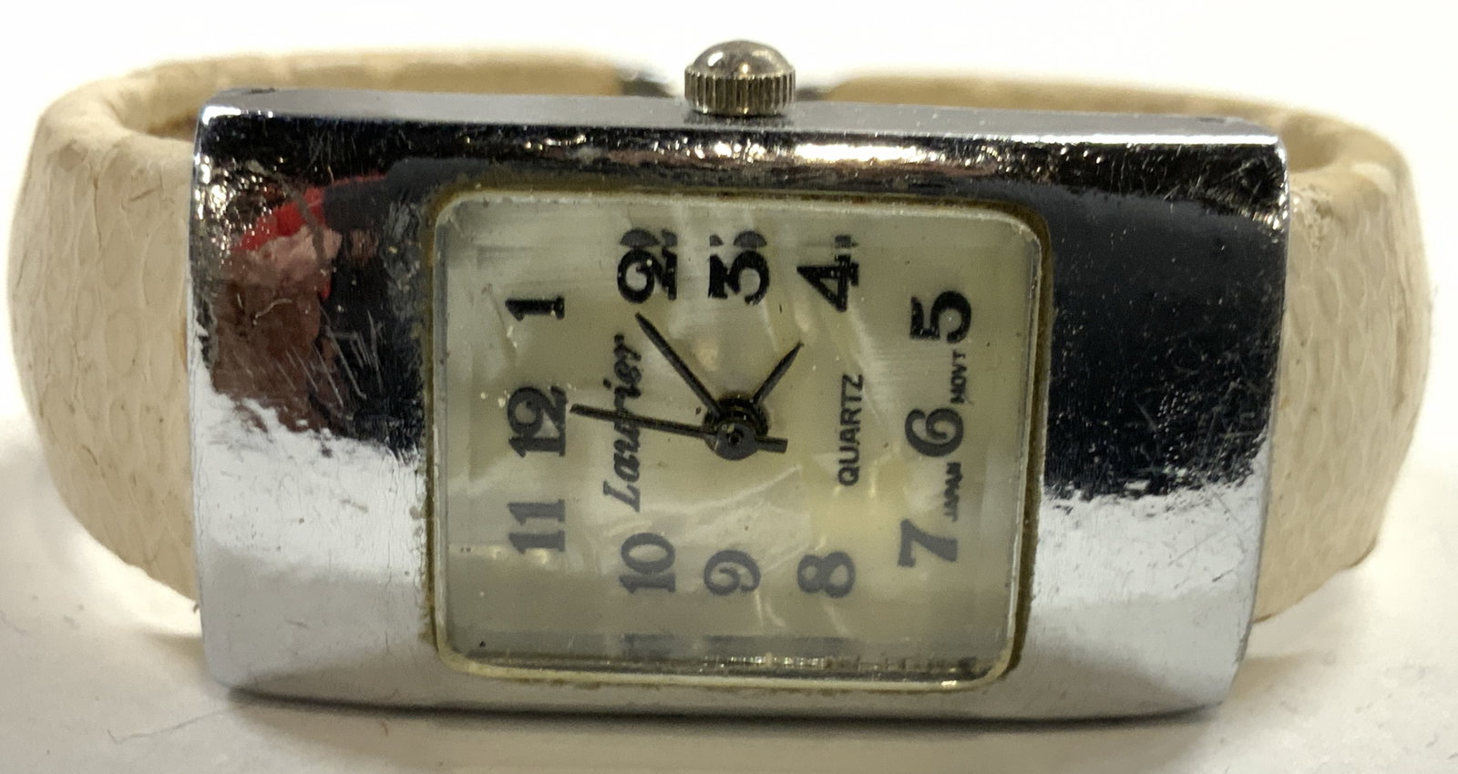LAURIER Womens Cuff Style Bracelet Watch: Watch face is trademarked LAURIER. Piece has white face with black toned numbers and hands. Piece has cream toned dimpled lining to cuff band. Watch measures approximately 2 inches wide with band .75 