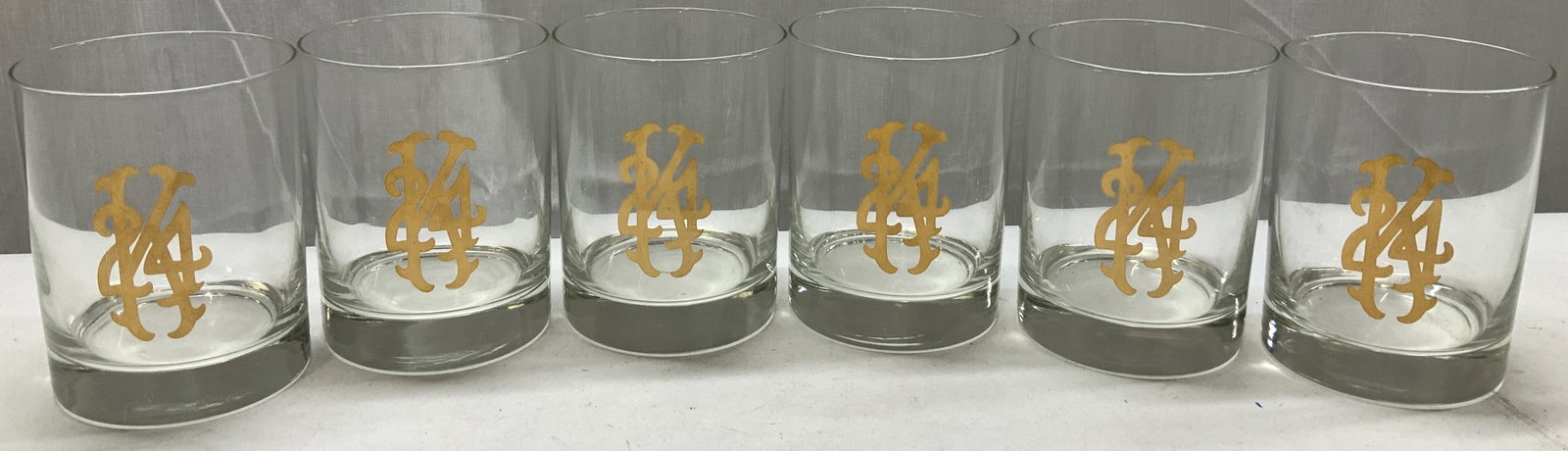 Lot 6+ Vntg Glass Tumbler W Gilt Monogram Design: Lot 6+ Vntg Glass Tumbler W Gold Monogram Design Clear glass tumbler feature an ornate gold monogram on the front. Surface wear consistent to age, use & exposure. Measurements: length 3.2in x width 3.