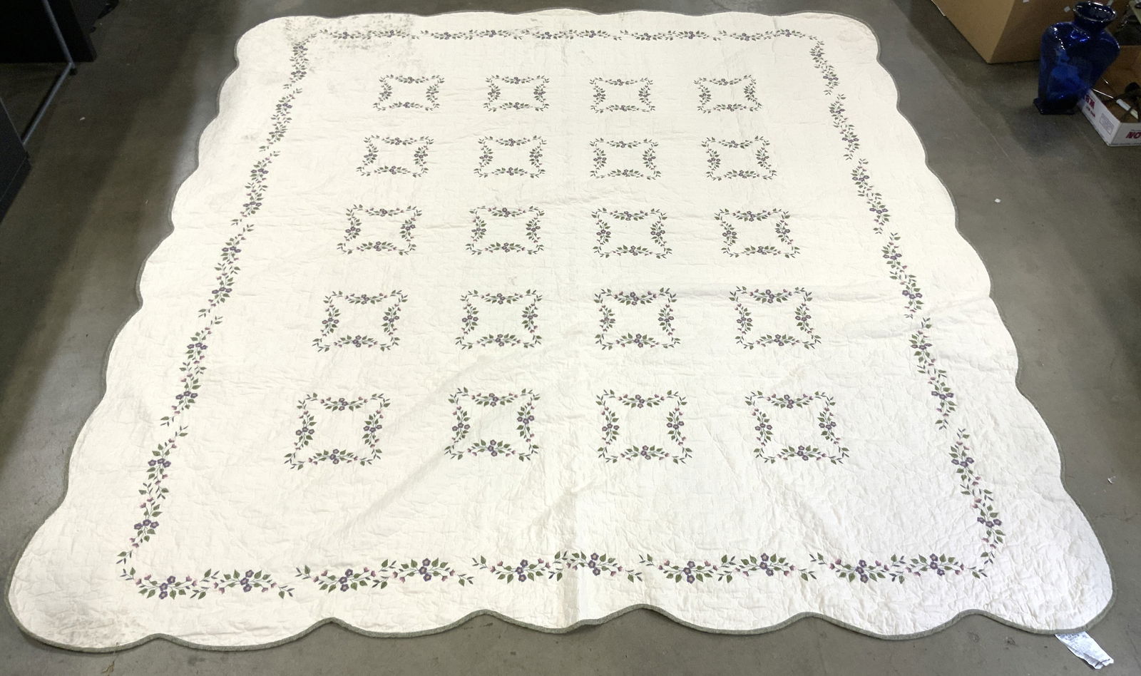 BETTER HOMES & GARDENS Floral Cotton Blnkt: Tag reads BETTER HOMES & GARDEN. Blanket is cream toned with multi toned embroidered floral & leaf detail. Edges of blanket are green toned. Blanket measures approximately 100 inches square. Blanket,