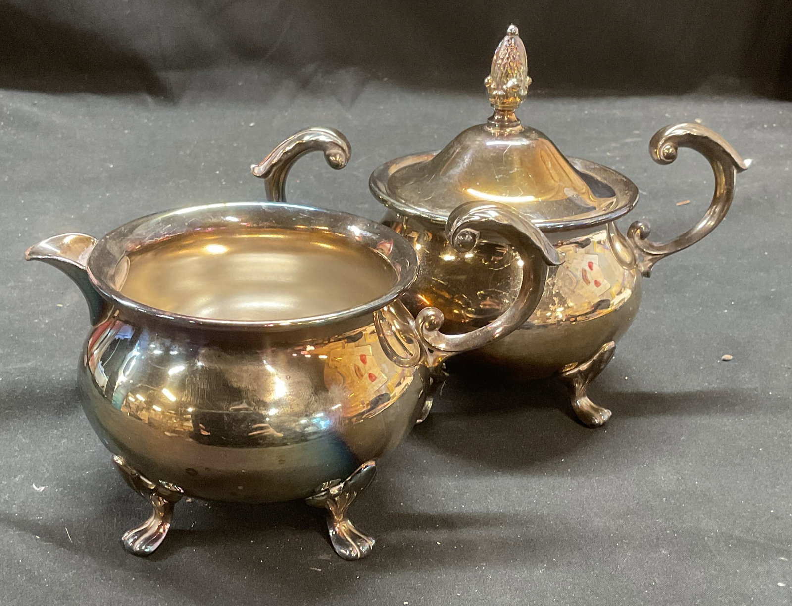 Pair Silver Plated Sugar Bowl & Creamer: Pair of vintage silver plated lidded sugar bowl and creamer. Matching claw footed and scroll designs. Larger piece measures approx 7 x 4.25 5.5 inches including lid. Some wear including scratching and