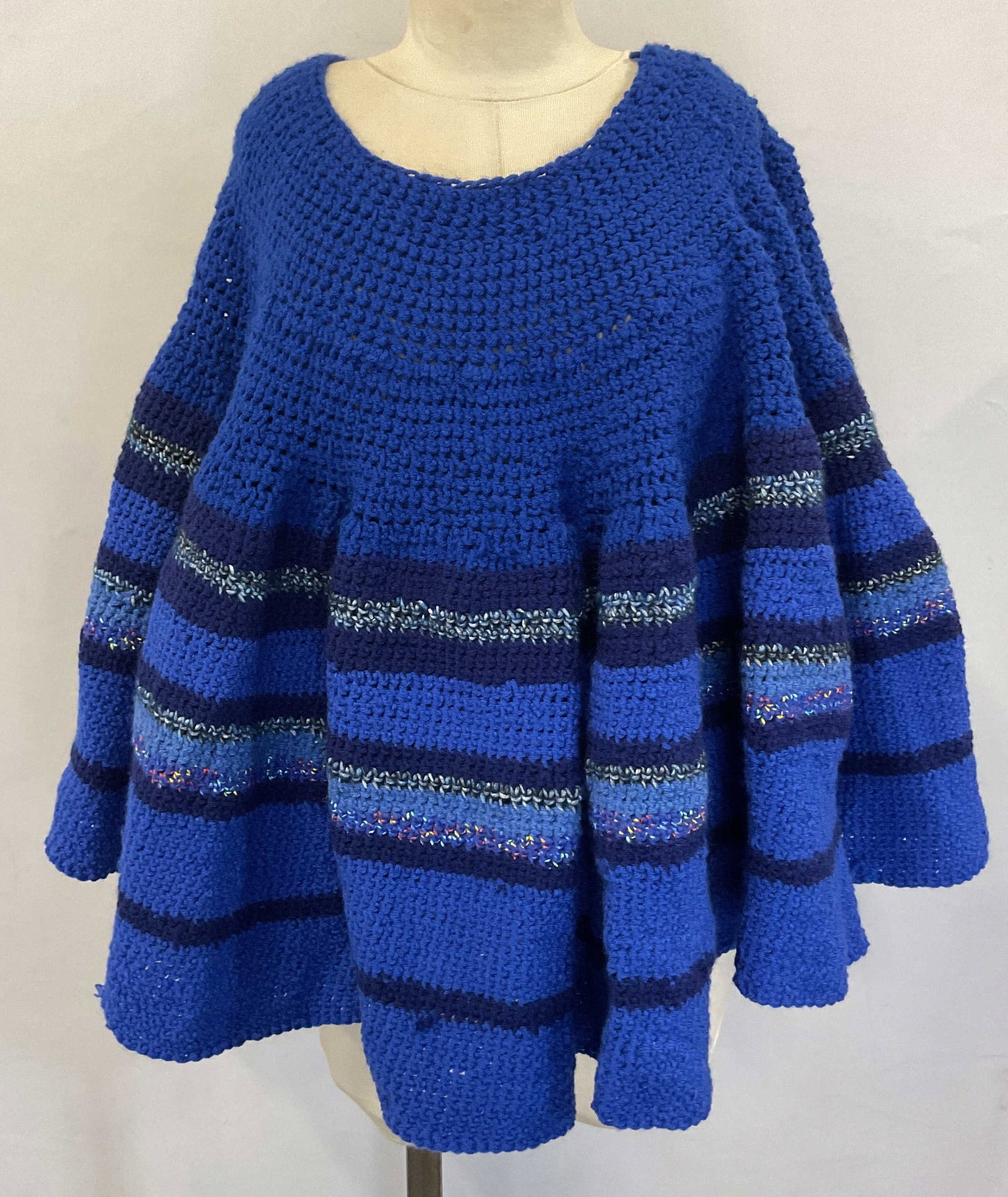 Vtg Hand Crafted Blue Poncho Shawl: Vintage hand crafted blue poncho shawl. Appears to be crochet or possibly knit. Blue, dark blue, mixed color stripes design. Appears to be Worsted or acrylic yarn. 21 inches long. Some wear consistent