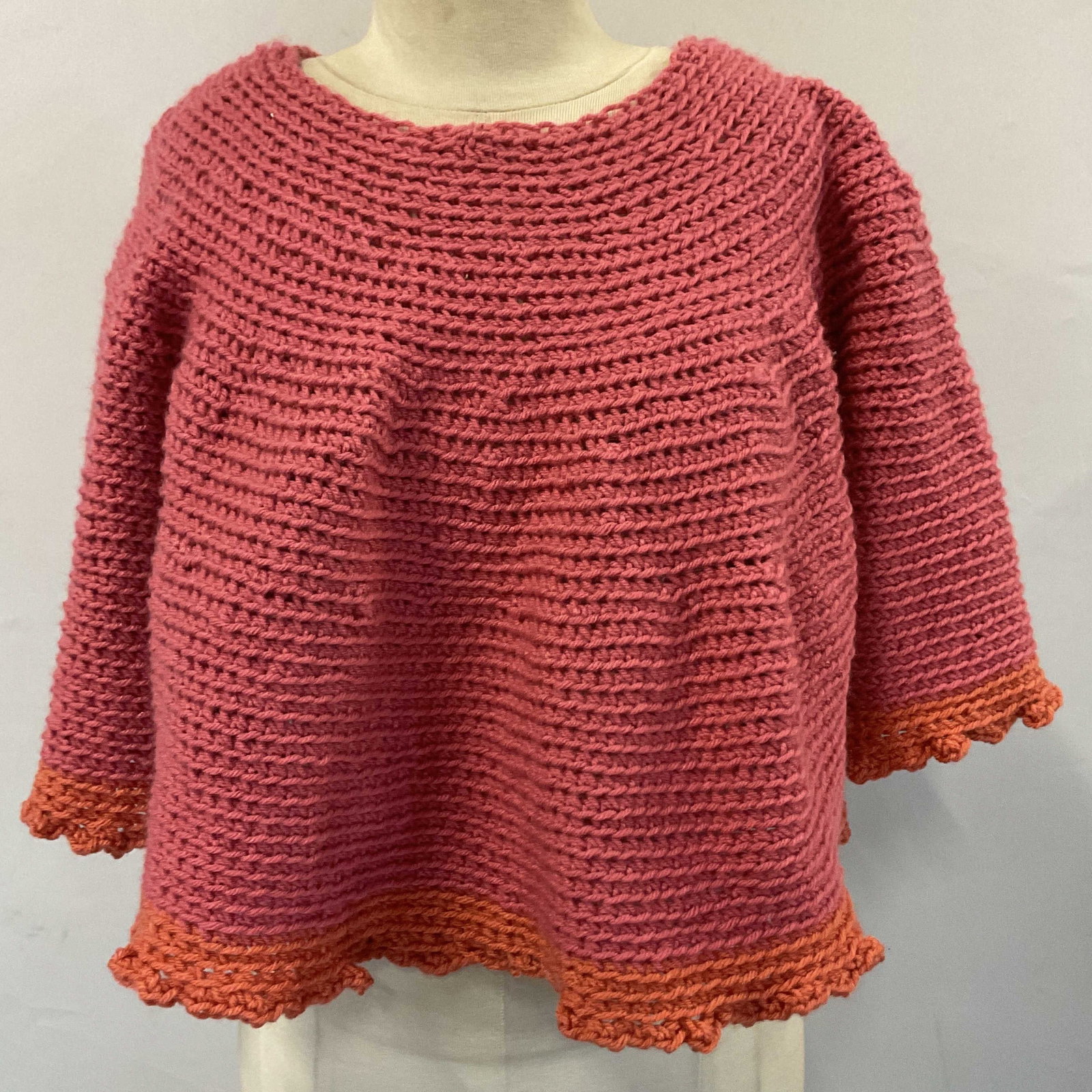 Vtg Hand Crafted Pink Orange Poncho Shawl: Vintage hand crafted pink orange poncho shawl. Appears to be crochet or possibly knit. Solid pink design with orange rim. Appears to be acrylic or Worsted yarn. 16 inches long. Some wear consistent wi