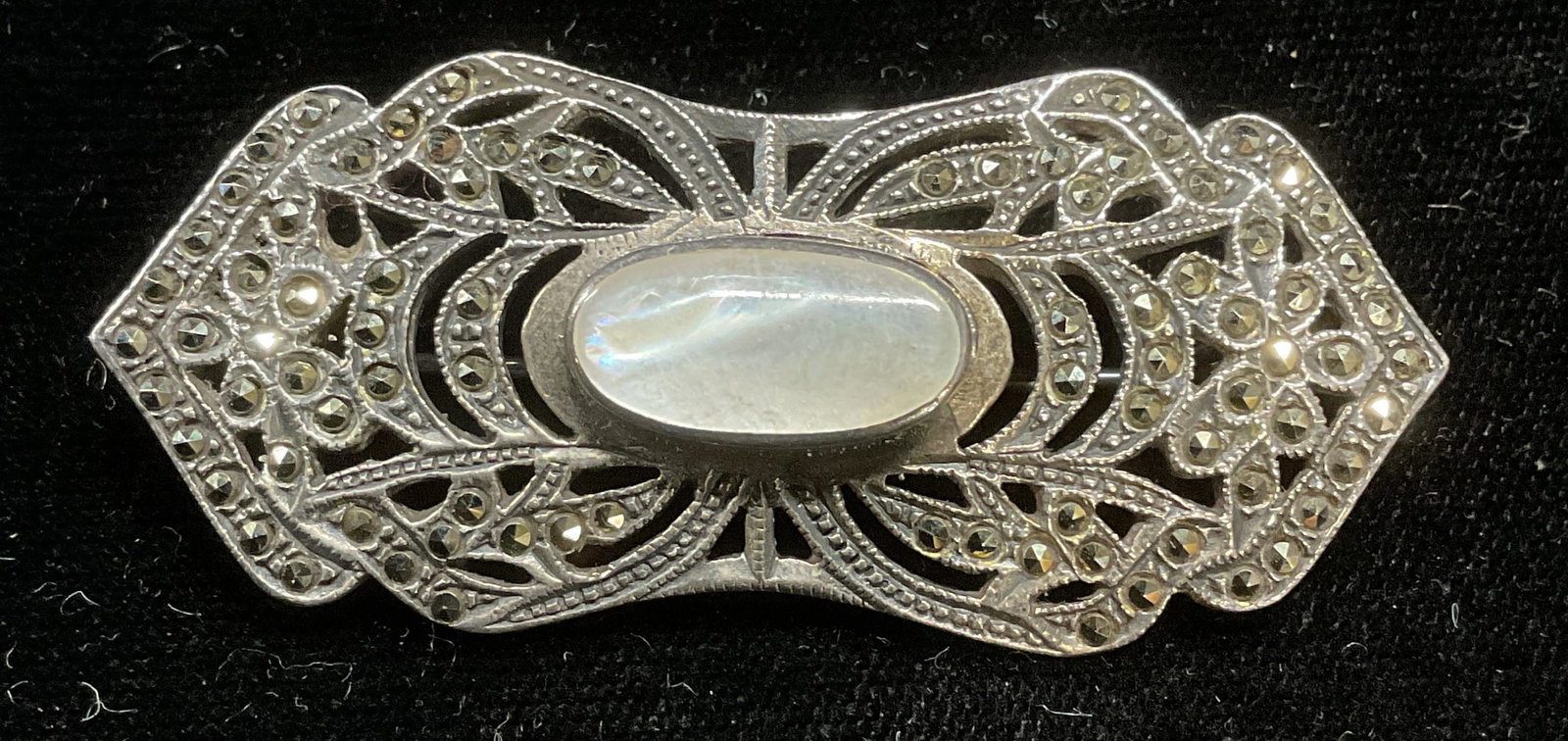 Vintage Sterling Silver MOP Marcasite Brooch: Vintage sterling silver art deco style brooch with mother of pearl and marcasite. Marked sterling. Measures approx 1 x 2.25 inches. Total weight 13.5 grams. Some wear including scratching. Jewelry, es