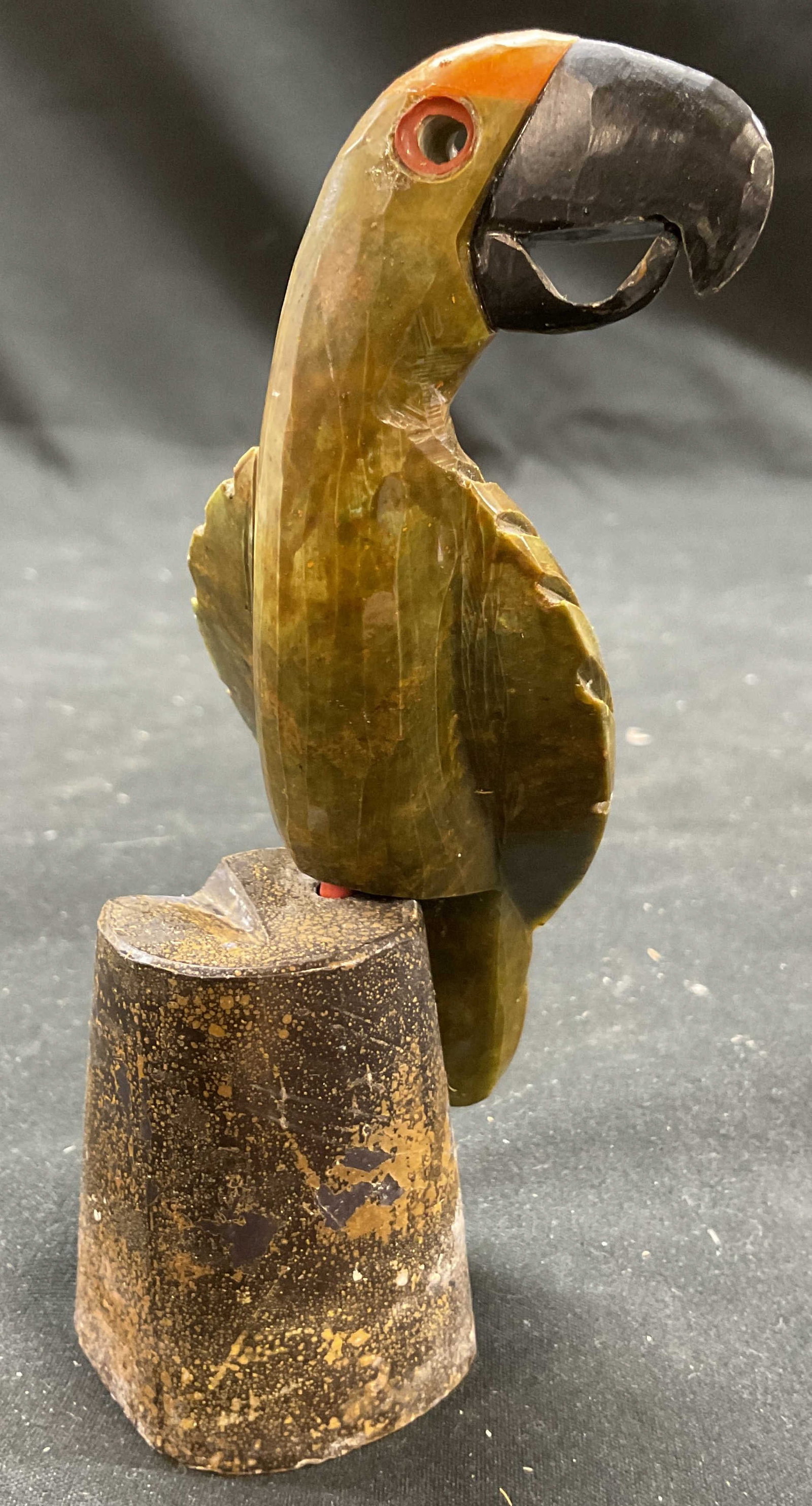 Vtg Hand Carved Stone Parrot Figurine: Vintage hand carved stone parrot figurine. Olive green carved stone parrot figurine stature. Perched on detachable brown stump. Measures approximately 5 x 2.25 inches. Some surface wear including resi
