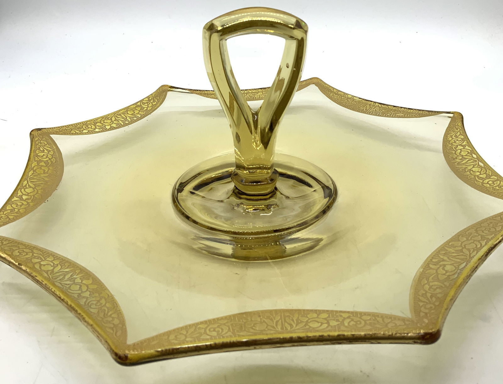 Vntg Amber Depression Glass Octagonal Cake Tray: Cake tray feature a distinctive octagonal shape with a gold-decorated rim. Rim features etched floral patterns & a glass handle in the center. Tray is depression glass material & an amber color. Surfa