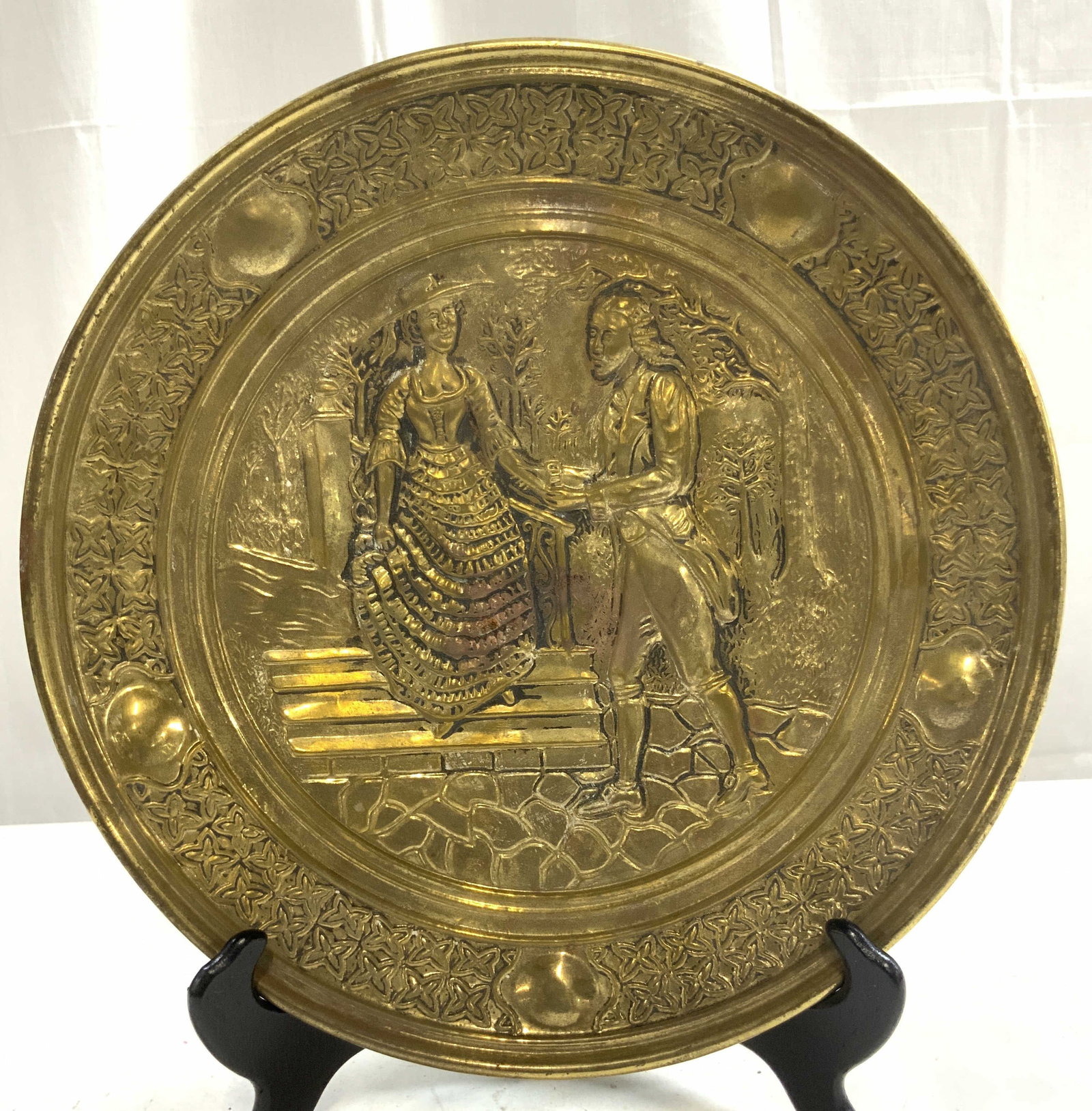 Vtg English Repousse Courting Couple Garden Scene: Backside inscribed MADE IN ENGLAND. Repousse embossed scene appears to be vintage possibly antique. Depicts a male figure courting a female figure in a garden scene. Piece has circular form. Embossed 